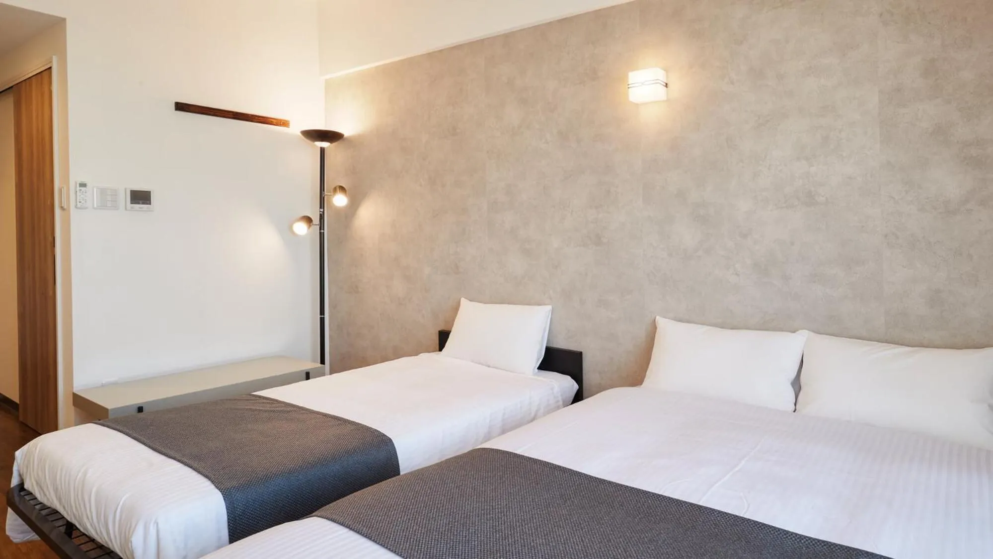 Bed in New Normal Hotel in NAMINOUE ニューノーマルホテルイン波の上