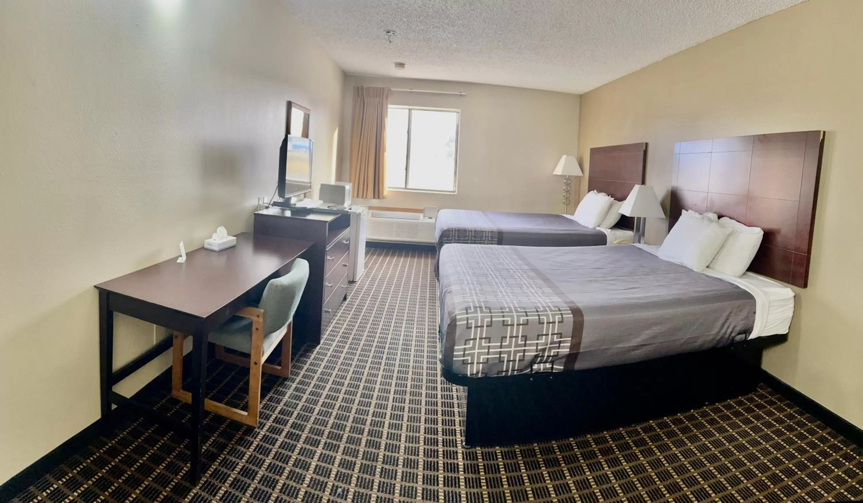 Bed in Designer Inn and Suites