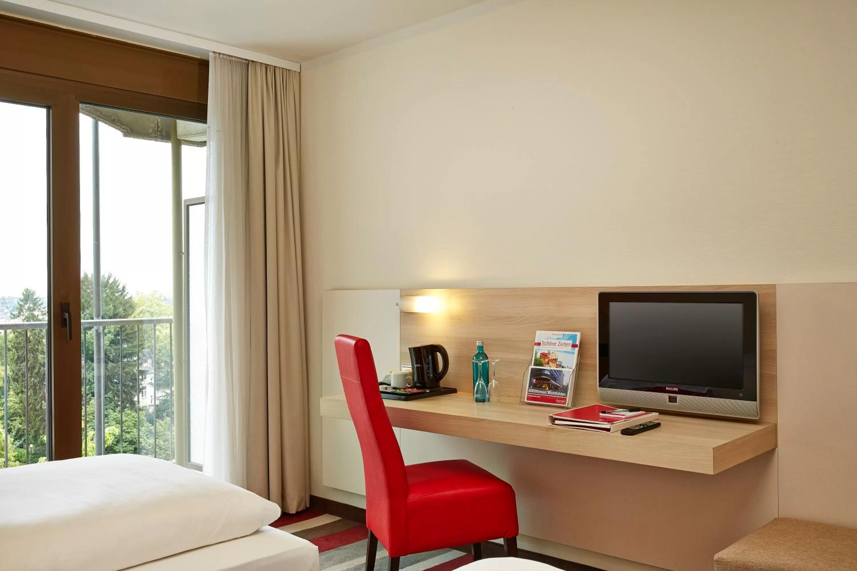 Seating area, Bed in H+ Hotel Bad Soden