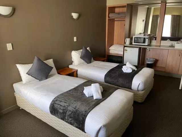 Bed in The Astor Hotel Motel