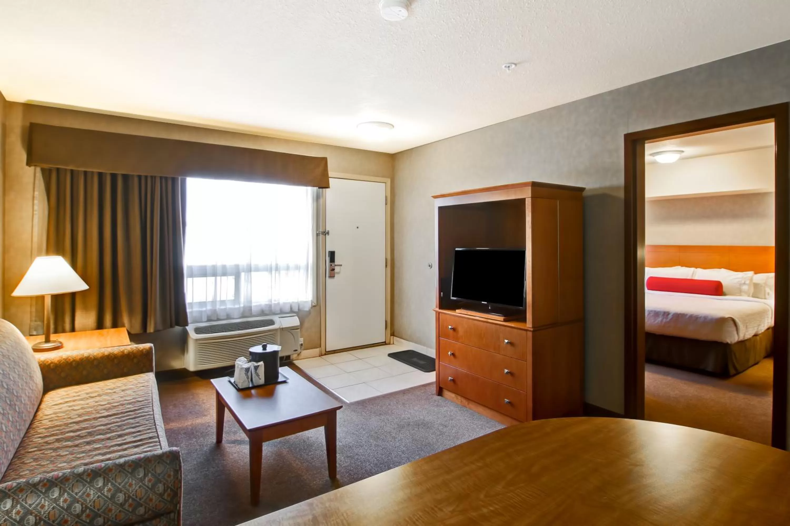 Seating area, Bed in Ramada by Wyndham Ponoka