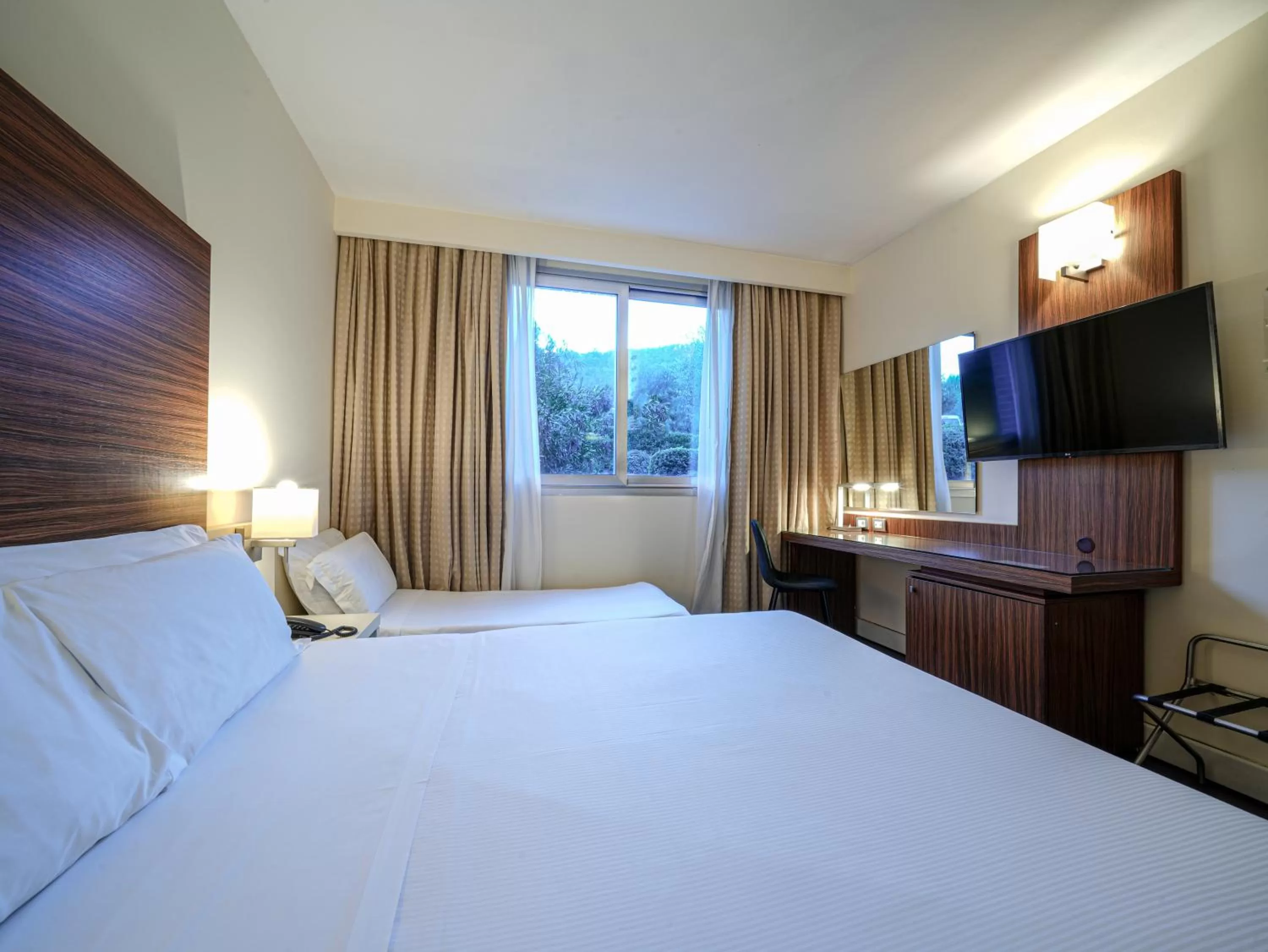 Bed in La Meridiana Bleisure Hotel