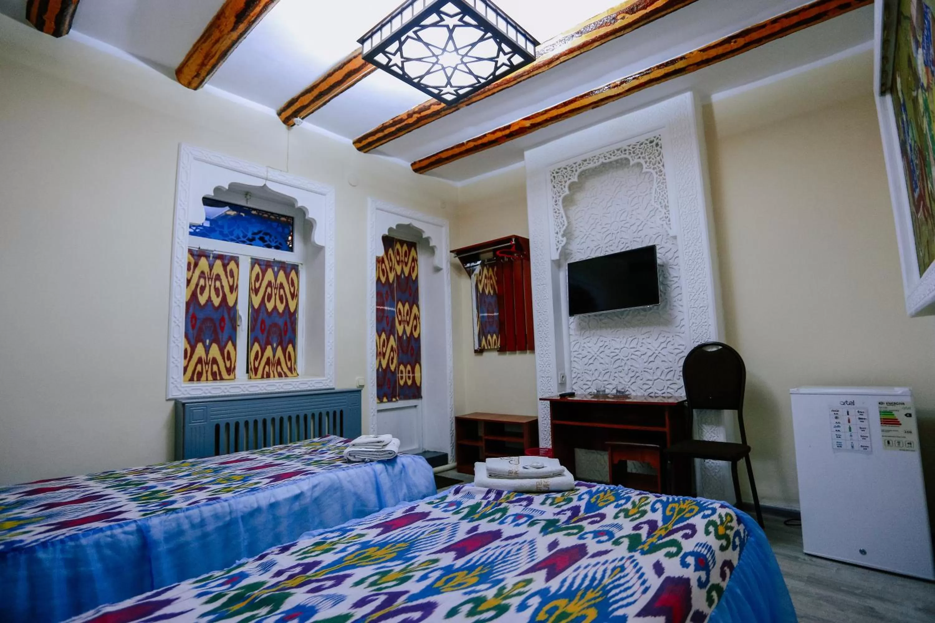 Communal lounge/ TV room, Bed in Bukhara house hotel
