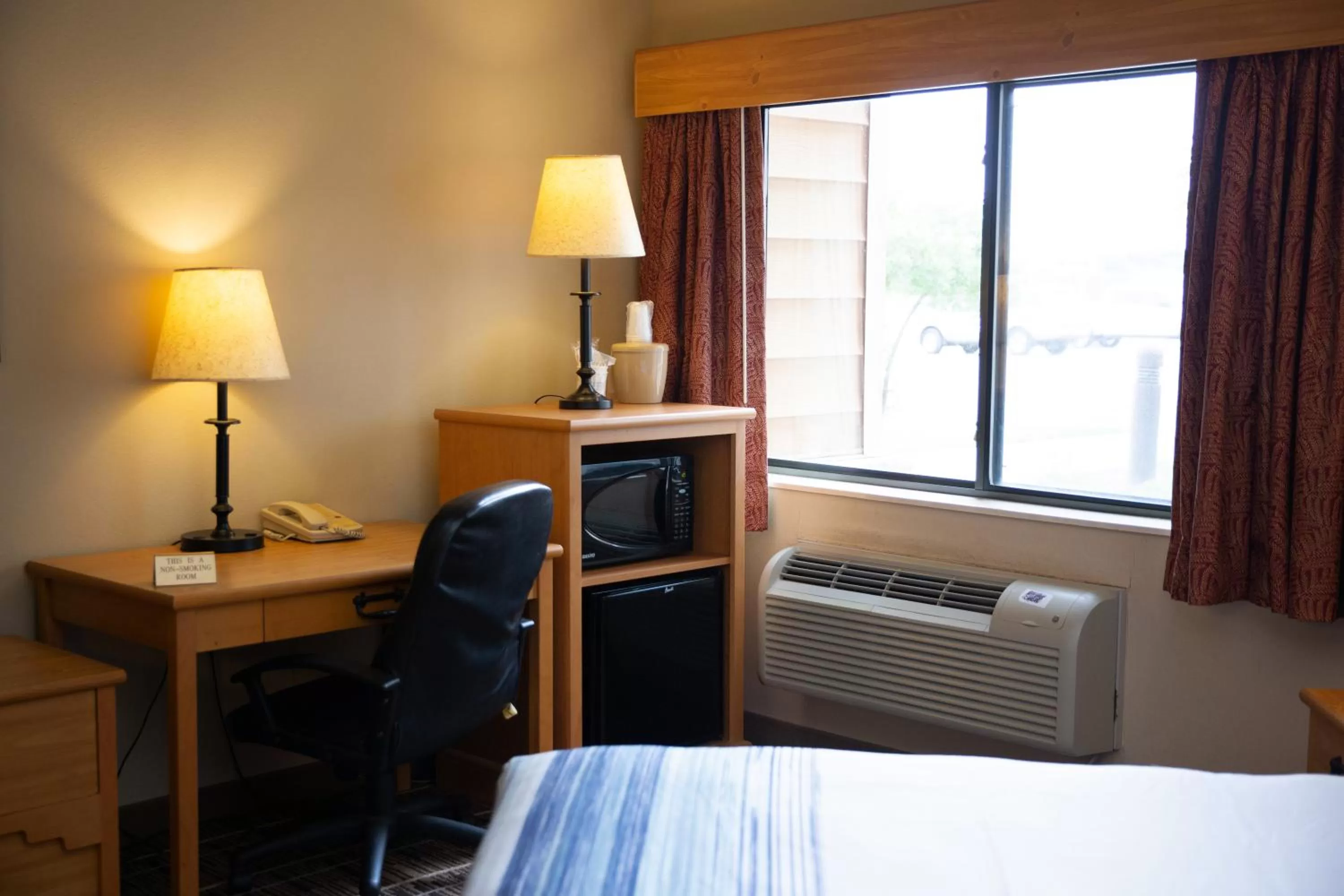 Living room, Bed in AmericInn by Wyndham Pampa Event Center