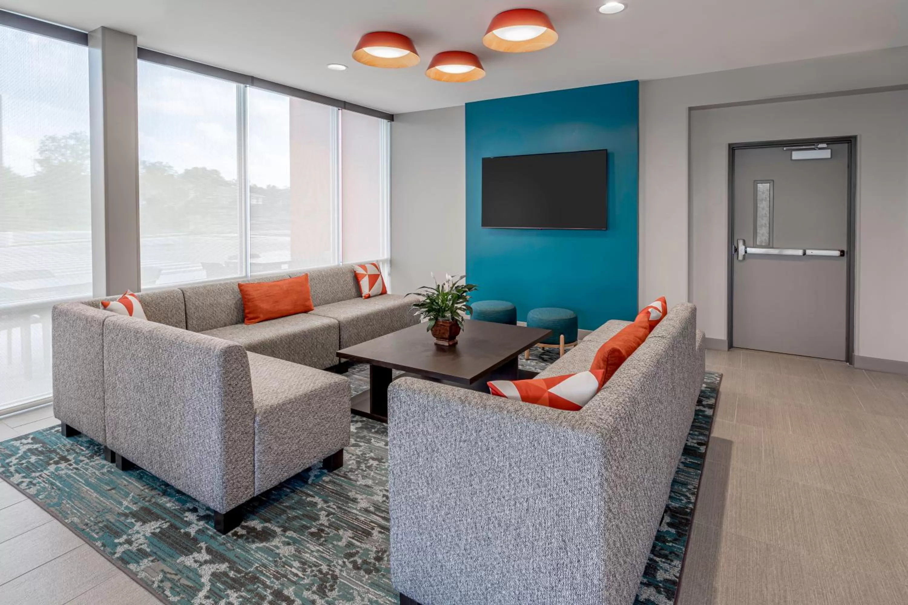 Communal lounge/ TV room in avid hotels Milwaukee West - Waukesha by IHG