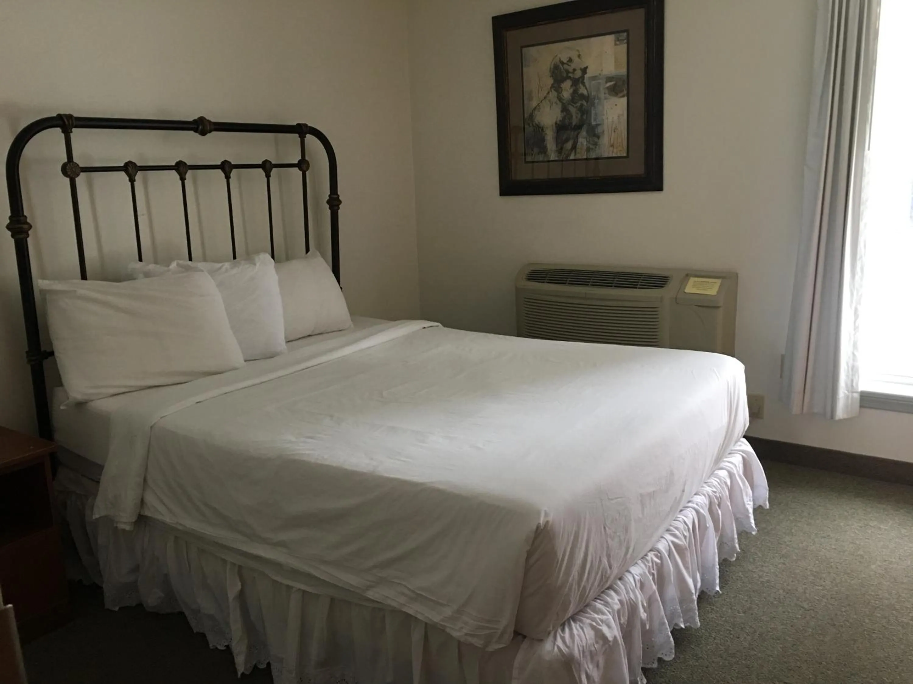 Bed in All Suites Inn Budget Host