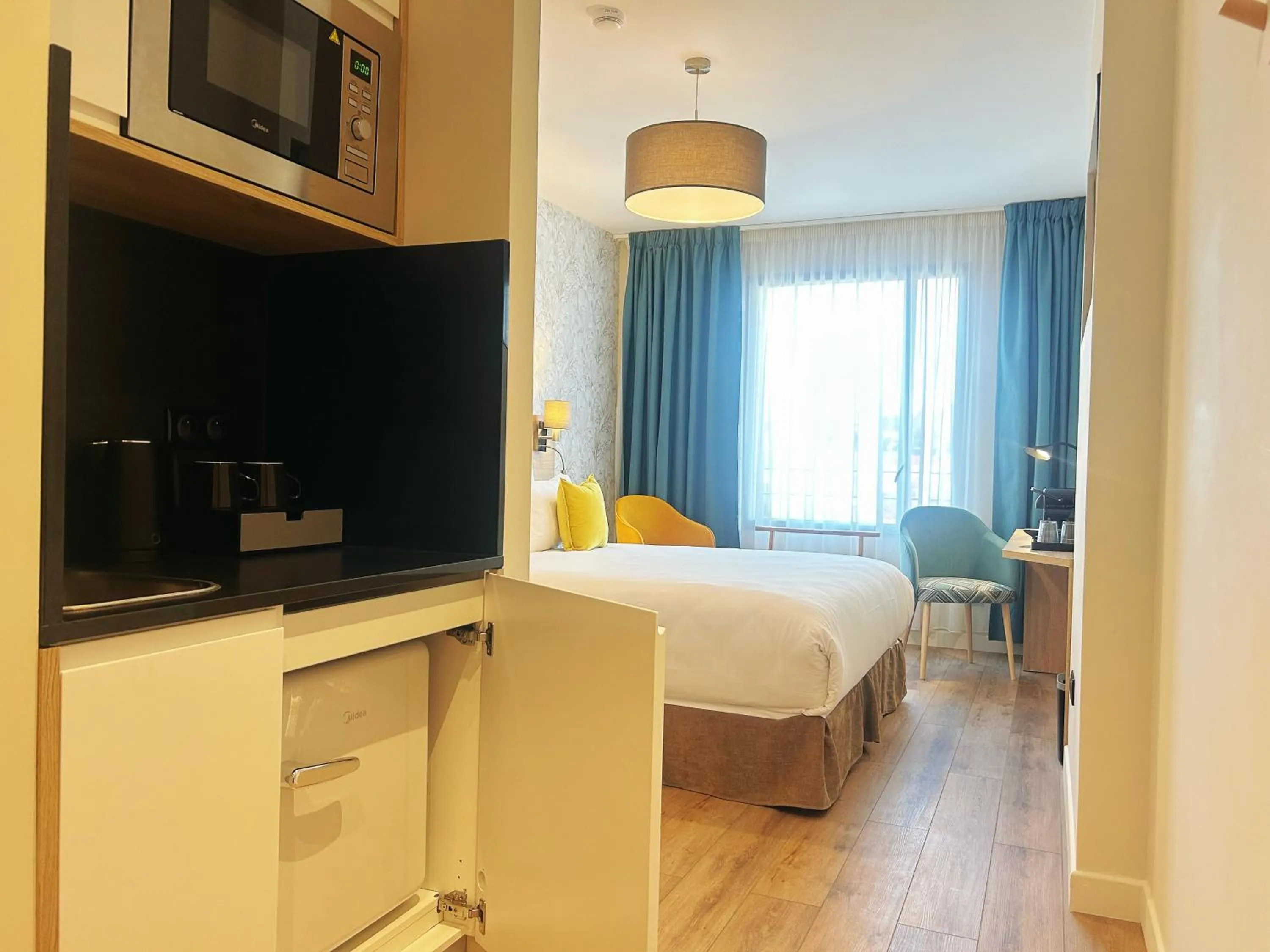 Kitchen or kitchenette, Bed in Hôtel Oden Paris Ivry