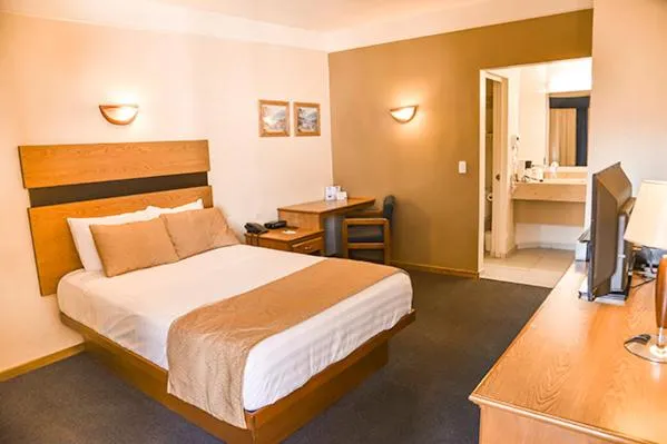 Bed in American Inn Hotel & Suites Parral