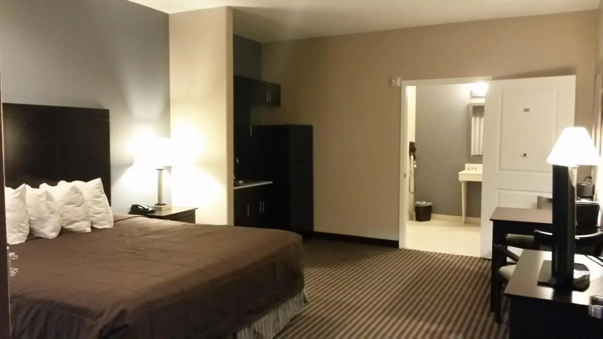 Kitchen or kitchenette, Bed in Atria Inn & Suites