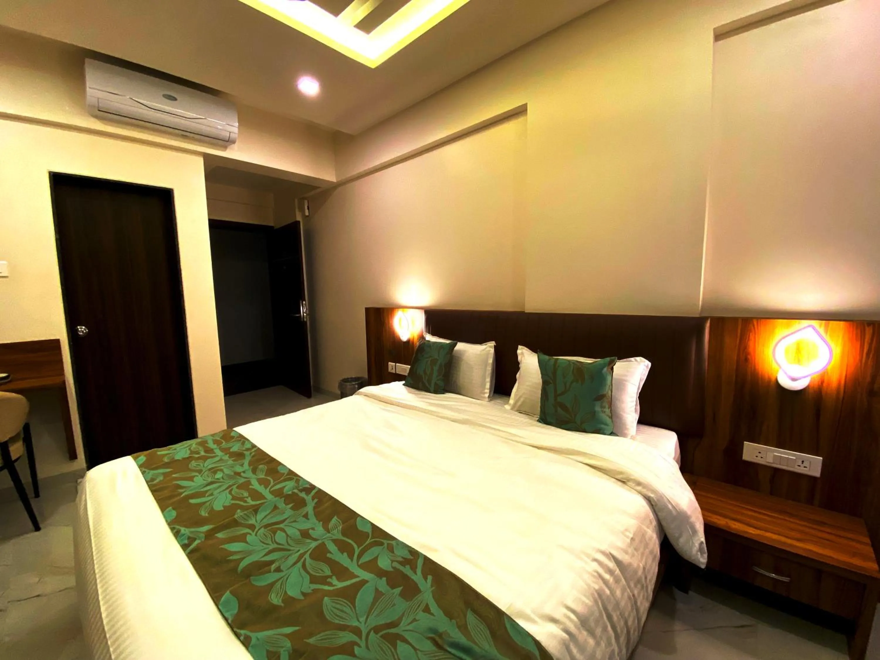 Bed in The Grand Sarovar Inn And Suites
