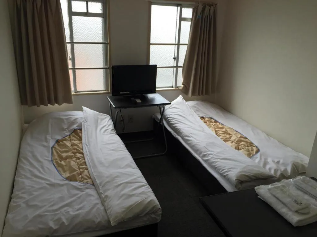 Bed in New Shochikubai Hotel