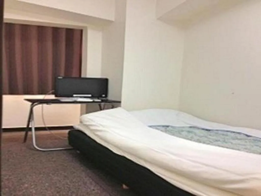 Bed in New Shochikubai Hotel