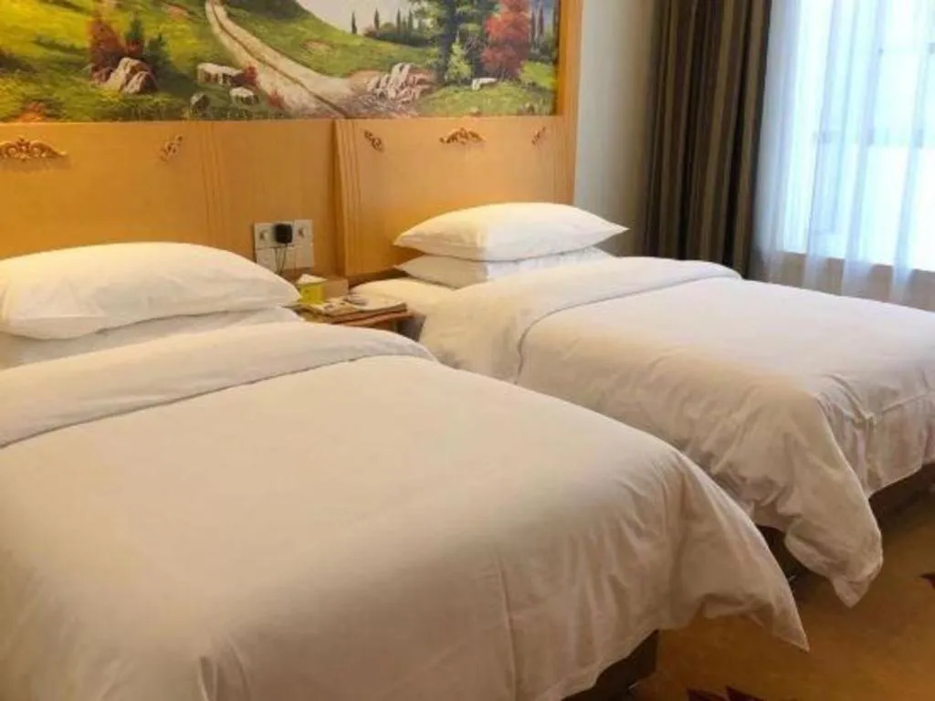 Bed in Vienna Hotel Guangdong Zhaoqing Sihui Tianguangxu