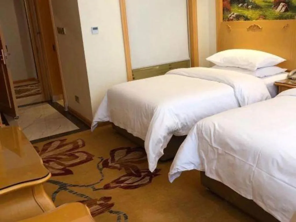 Bed in Vienna Hotel Guangdong Zhaoqing Sihui Tianguangxu