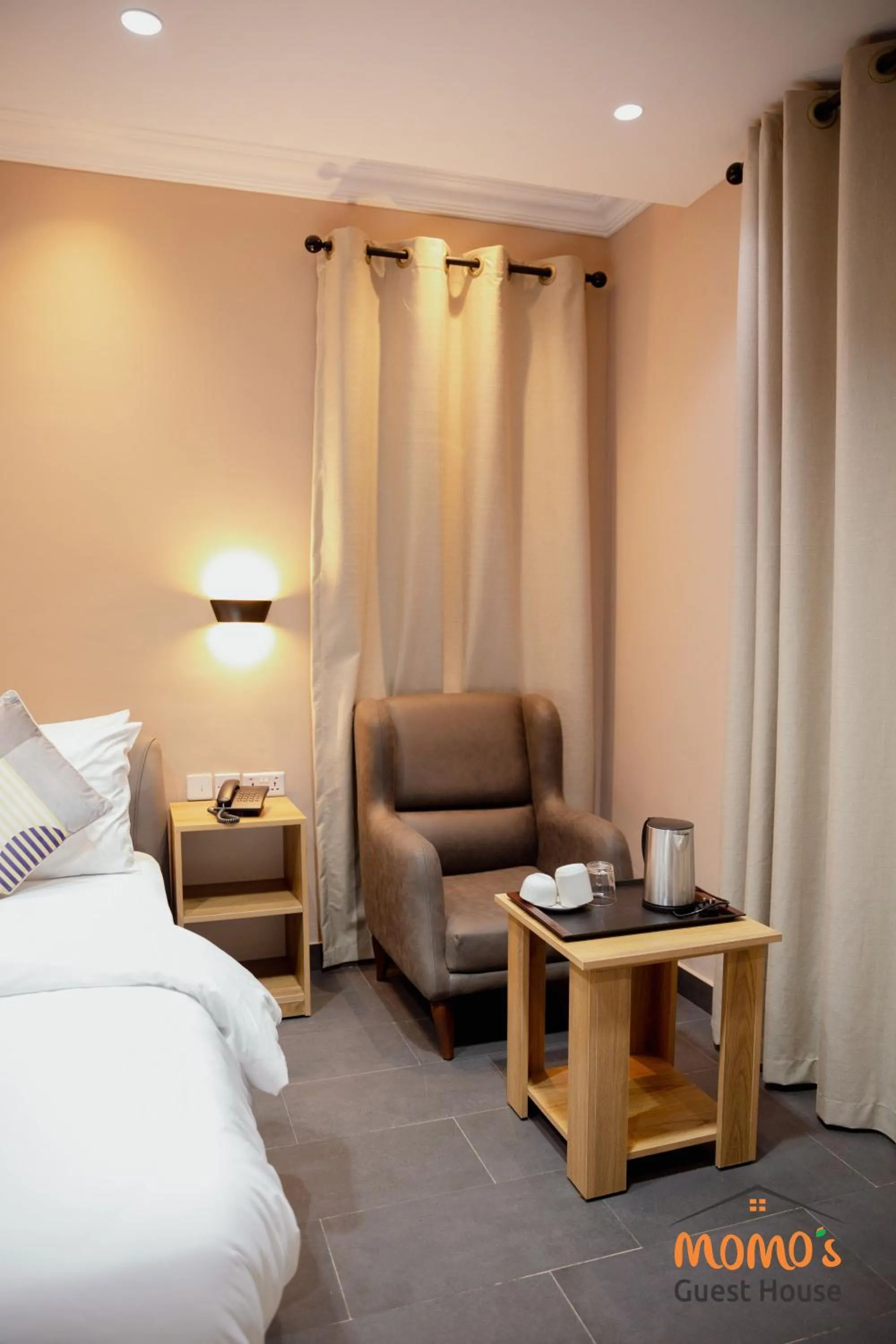 Seating area, Bed in Momo's Hotel