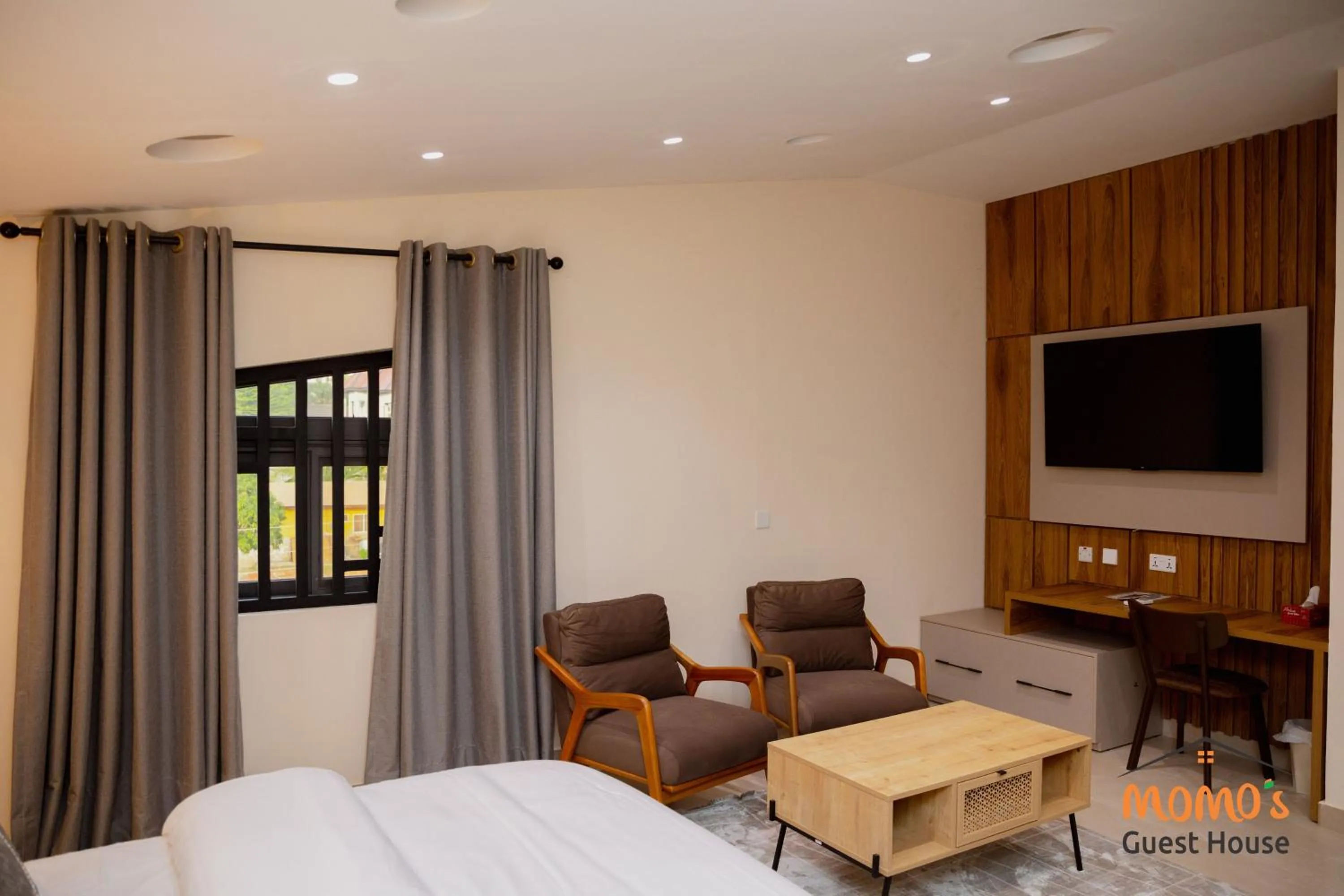 Seating area, Bed in Momo's Hotel