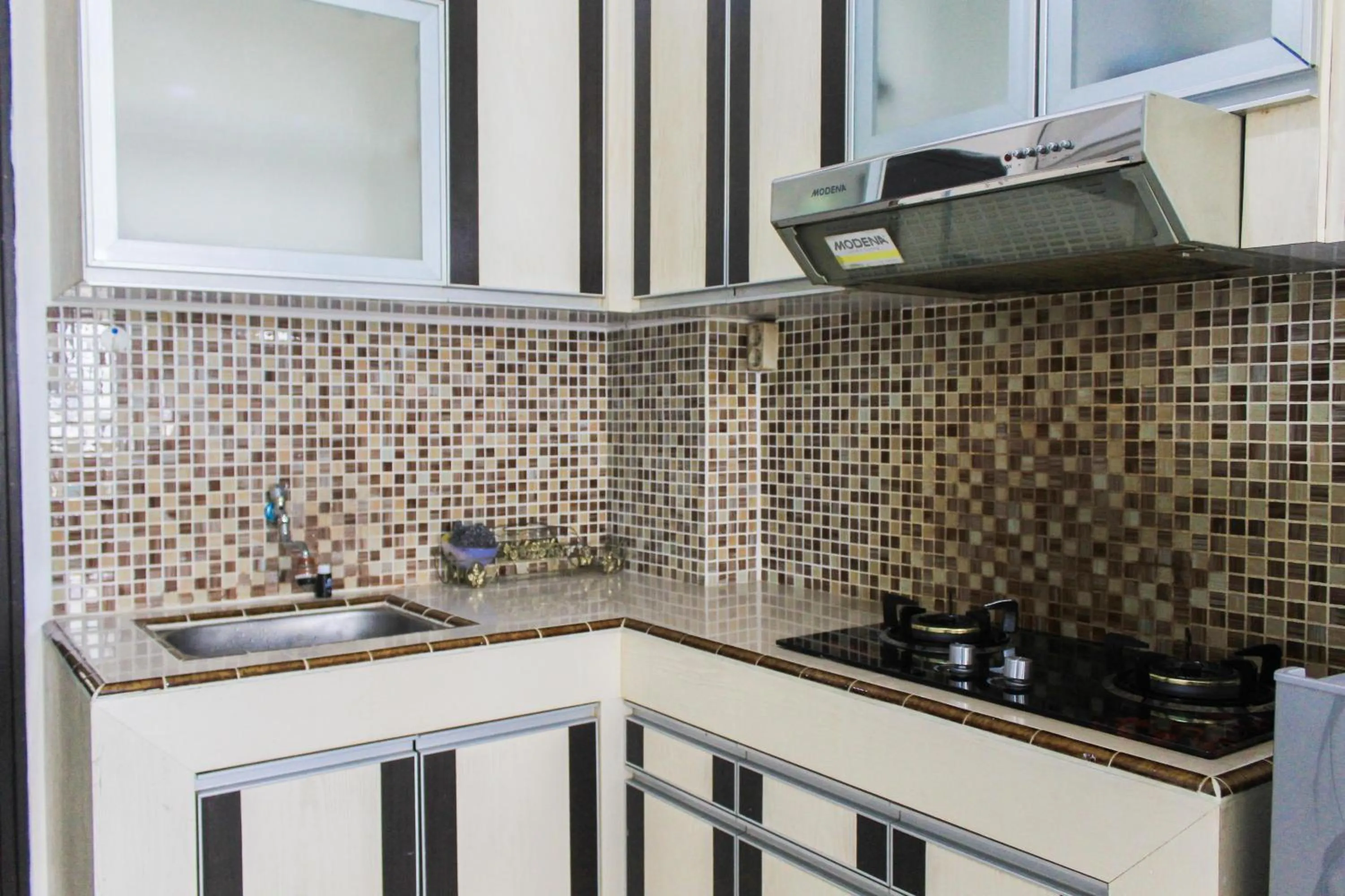 Kitchen or kitchenette in Best Price 1BR with Extra Room at Menara Latumenten Apartment Grogol By Travelio
