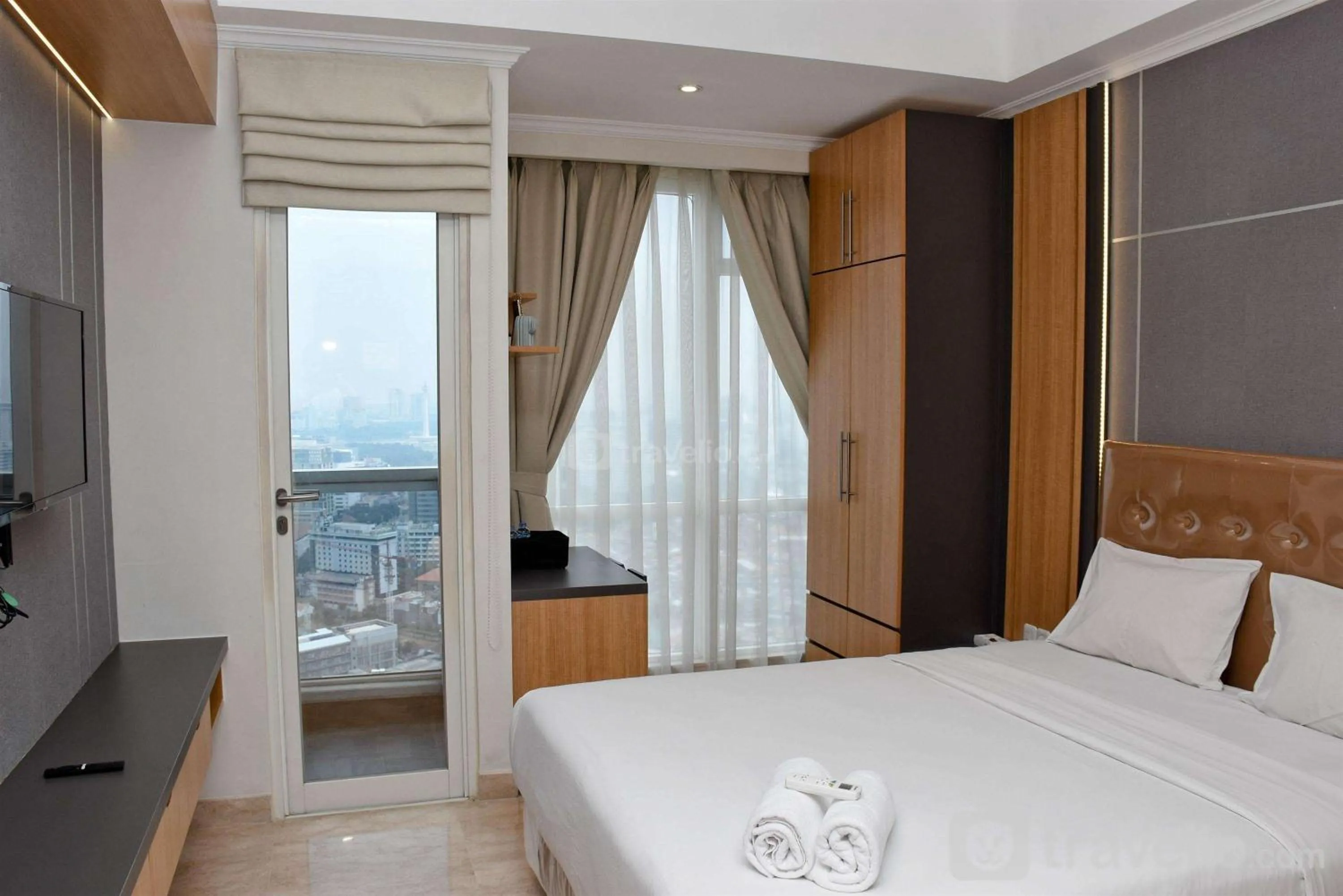 Bed in Cozy Living Studio at Menteng Park Apartment By Travelio