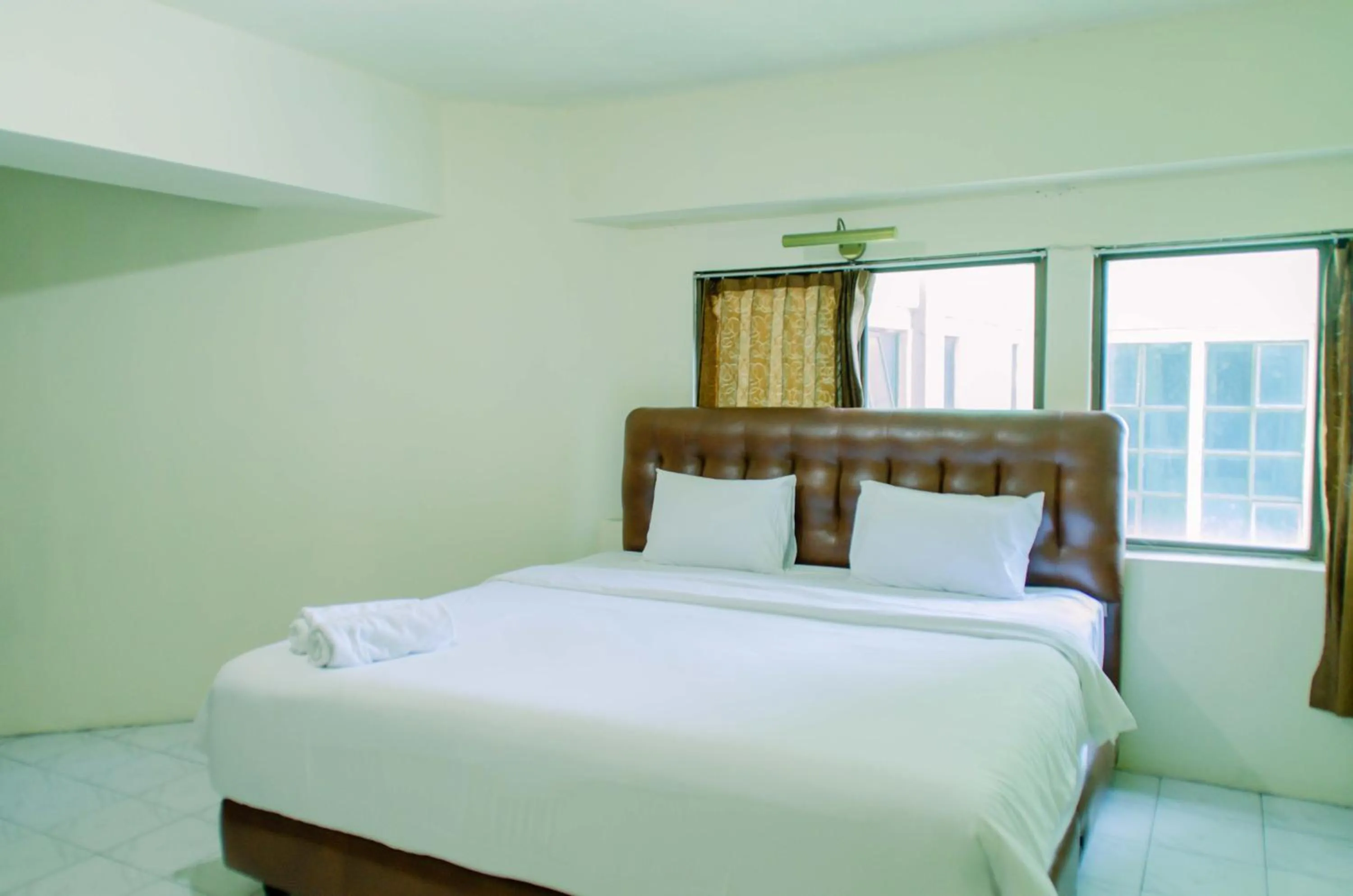 Bed in Spacious and Homey 3BR at Kondominium Rajawali Apartment By Travelio
