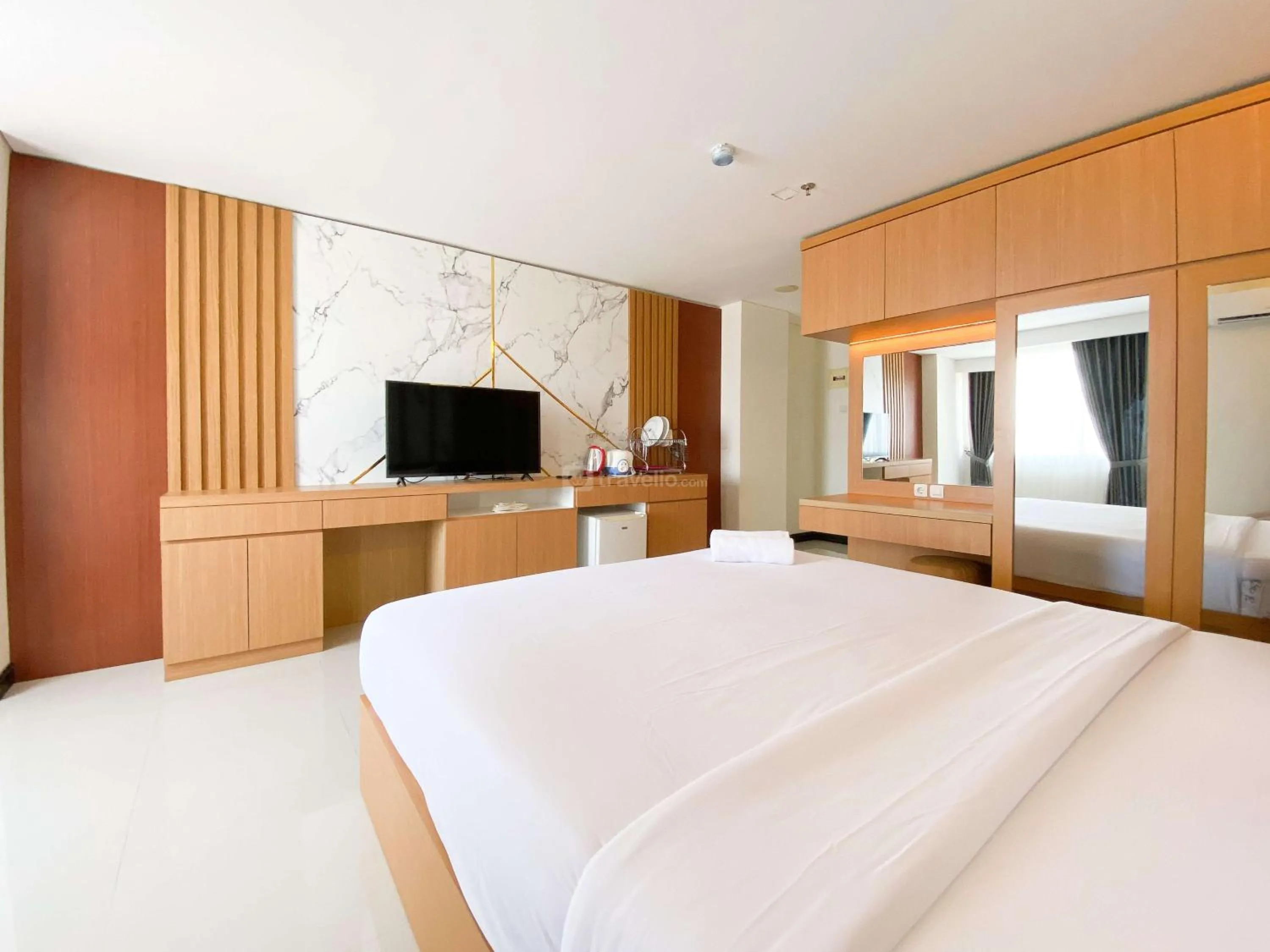 Bed in Homey and Strategic Studio (No Kitchen) at Sentraland Semarang Apartment By Travelio