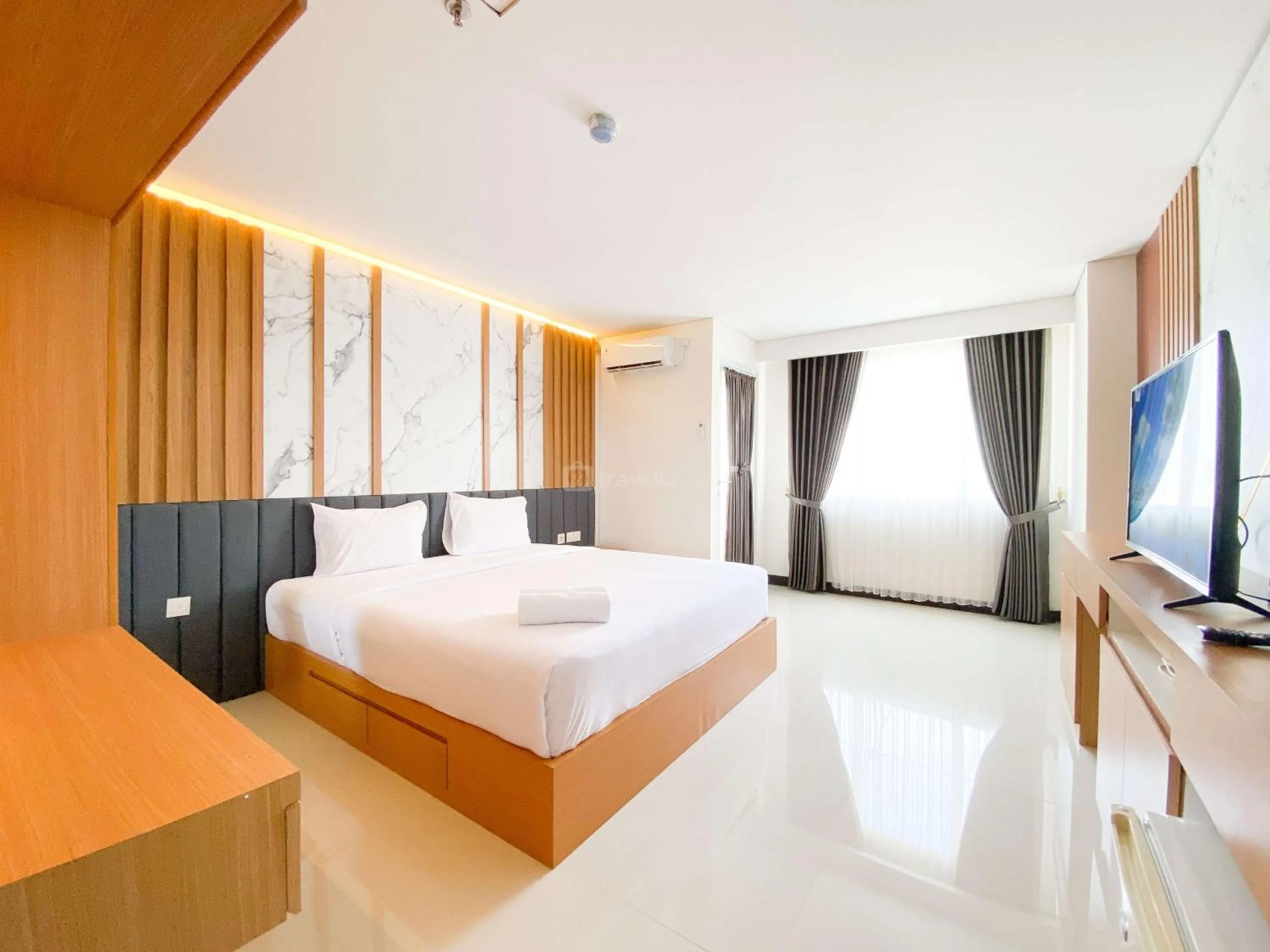Bed in Homey and Strategic Studio (No Kitchen) at Sentraland Semarang Apartment By Travelio
