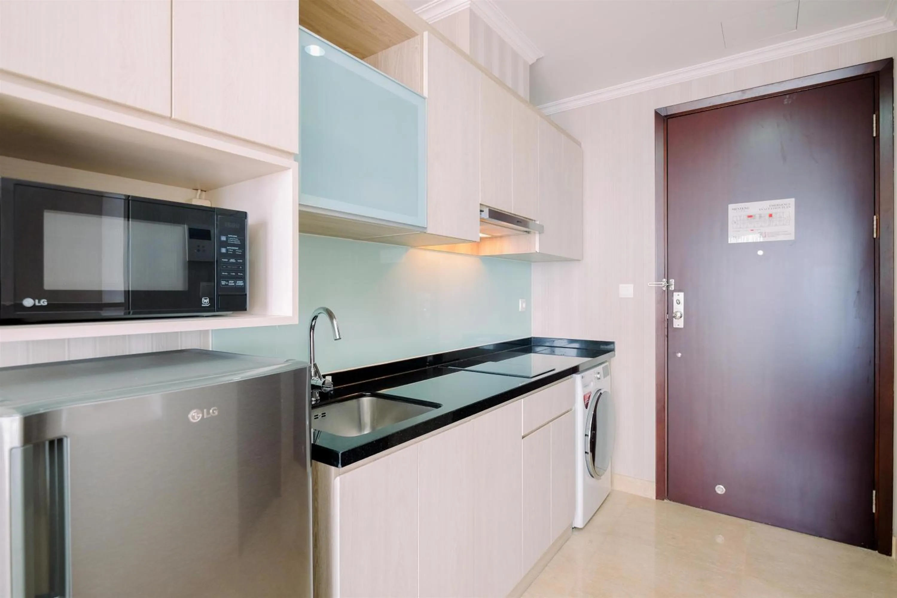 Kitchen or kitchenette in Comfort and Modern Look Studio Menteng Park Apartment By Travelio