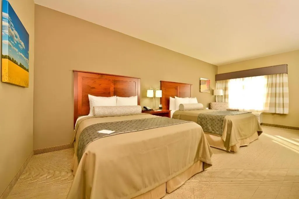 Bed in Green Mill Village Hotel & Suites, BW Signature Collection