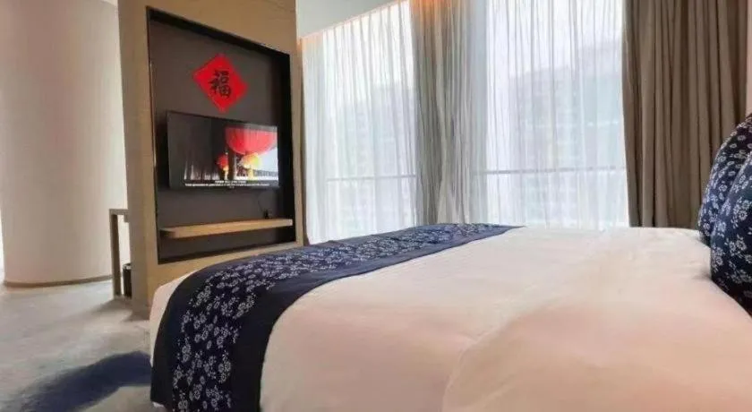 Bed in LONGYAN JINGHUA FLIPORT HOTEL
