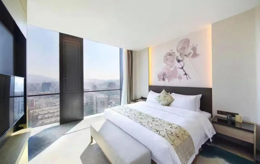 Bed in LONGYAN JINGHUA FLIPORT HOTEL