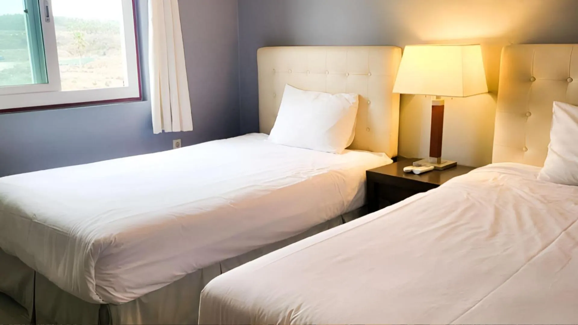 Bed in Jeju EQ Stay Hotel