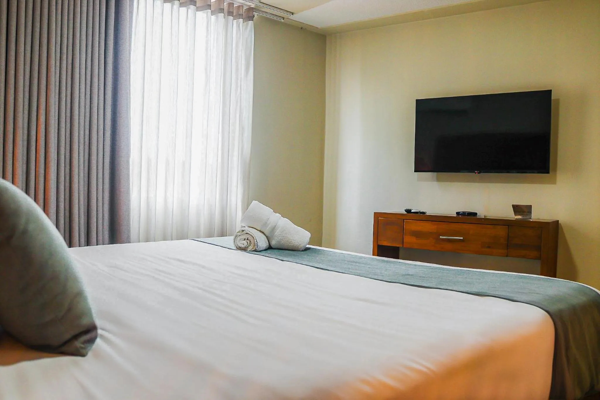 Bed in Majestic City Suites & Beach Hotel