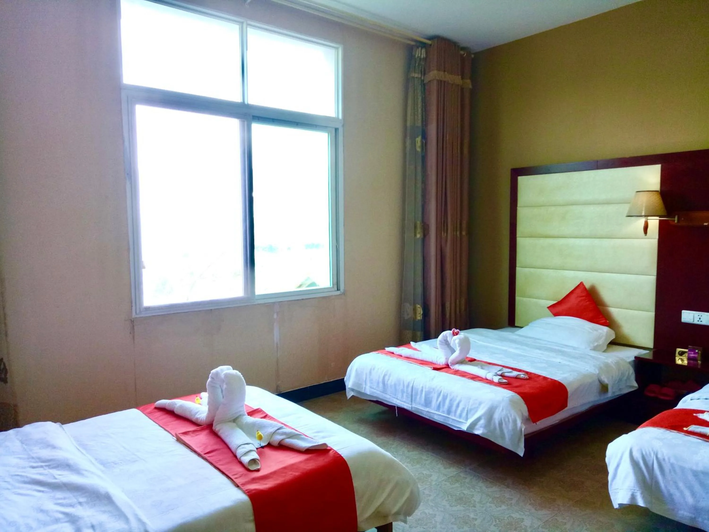 Bed in XiShuangBanNa International Aerial Garden South of Mekong River Business Hotel 傣江南商务酒店