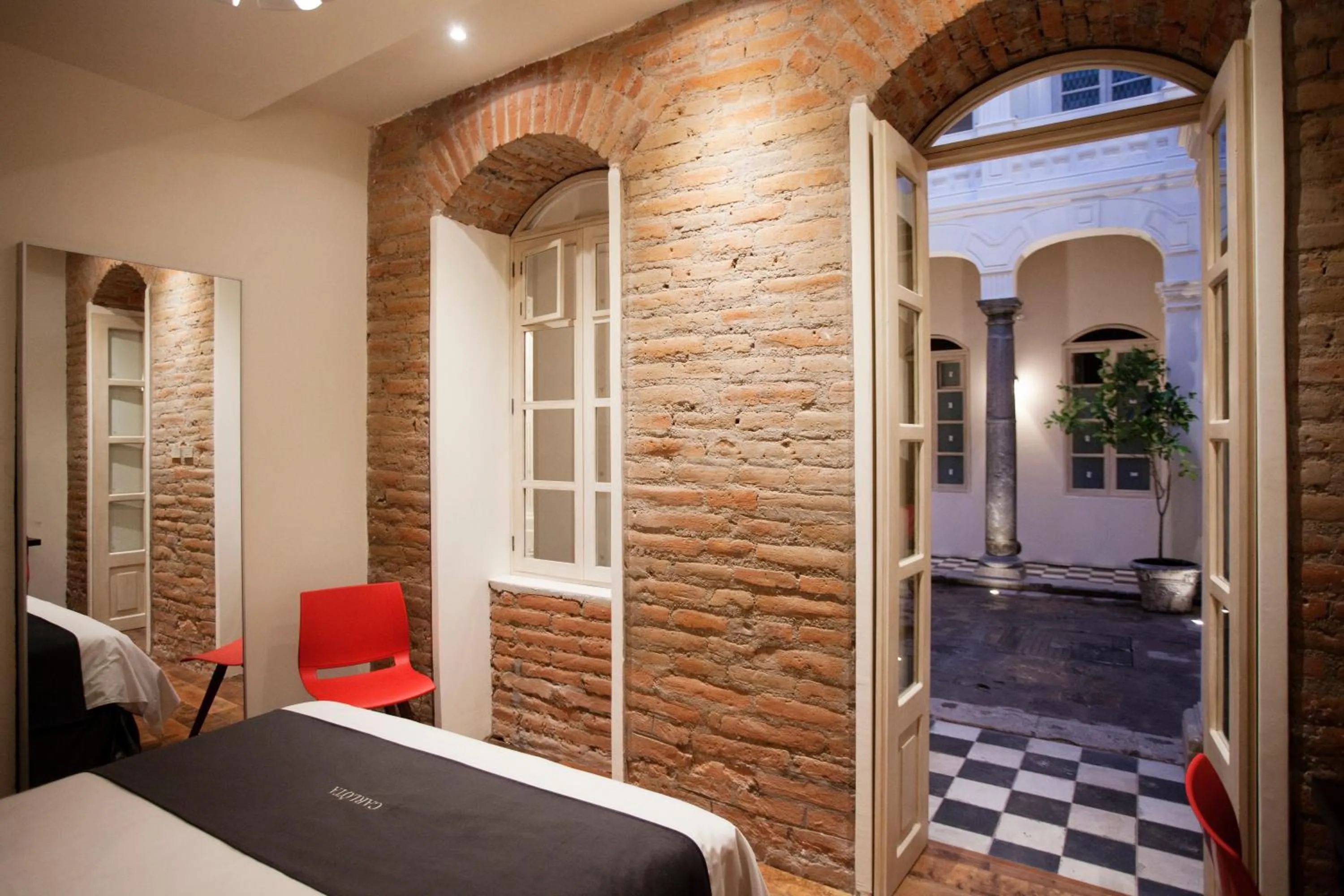 Inner courtyard view, Bed in Carlota Sustainable Design Hotel