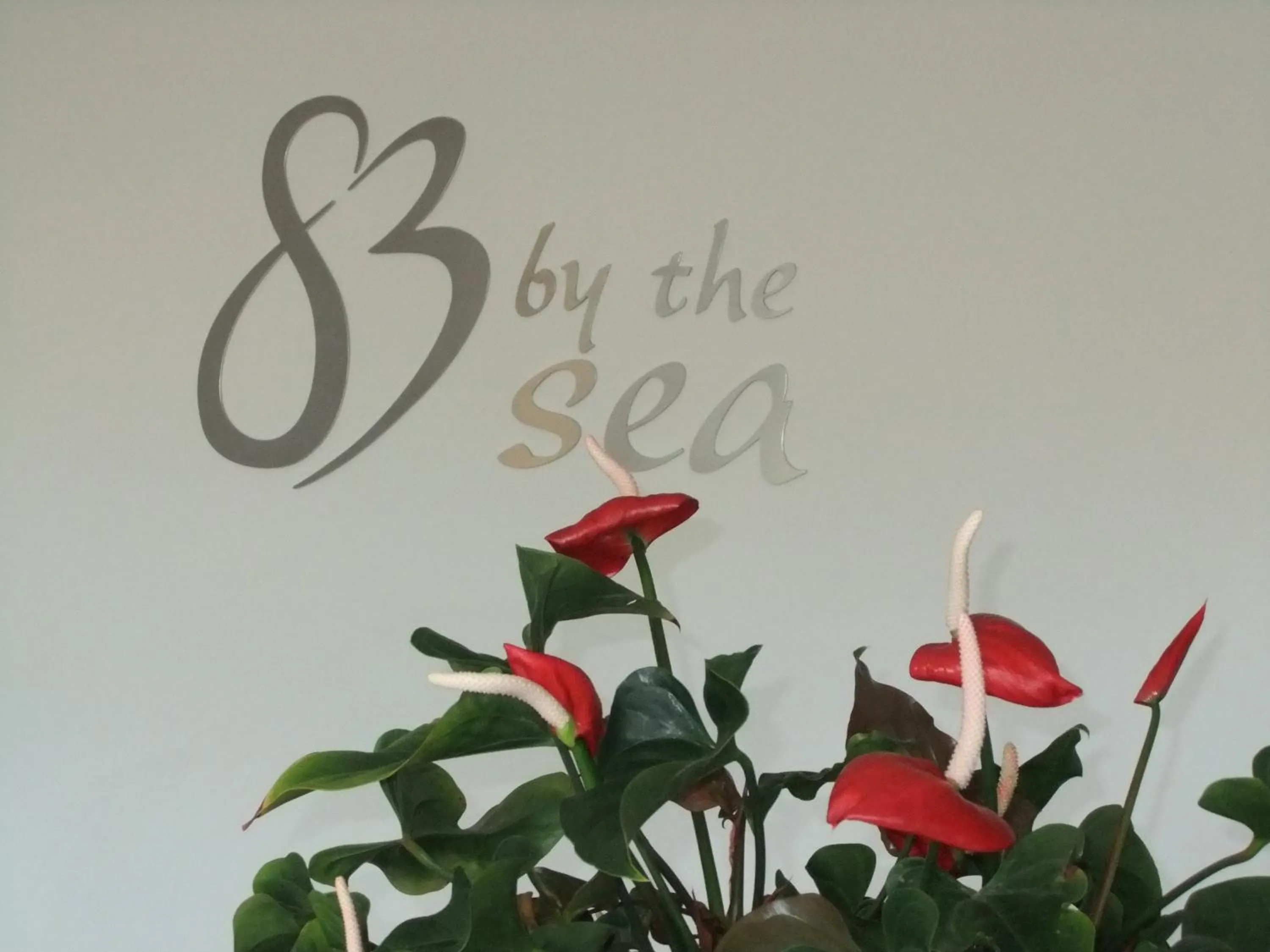 Property logo or sign in 83 By The Sea Motor Lodge