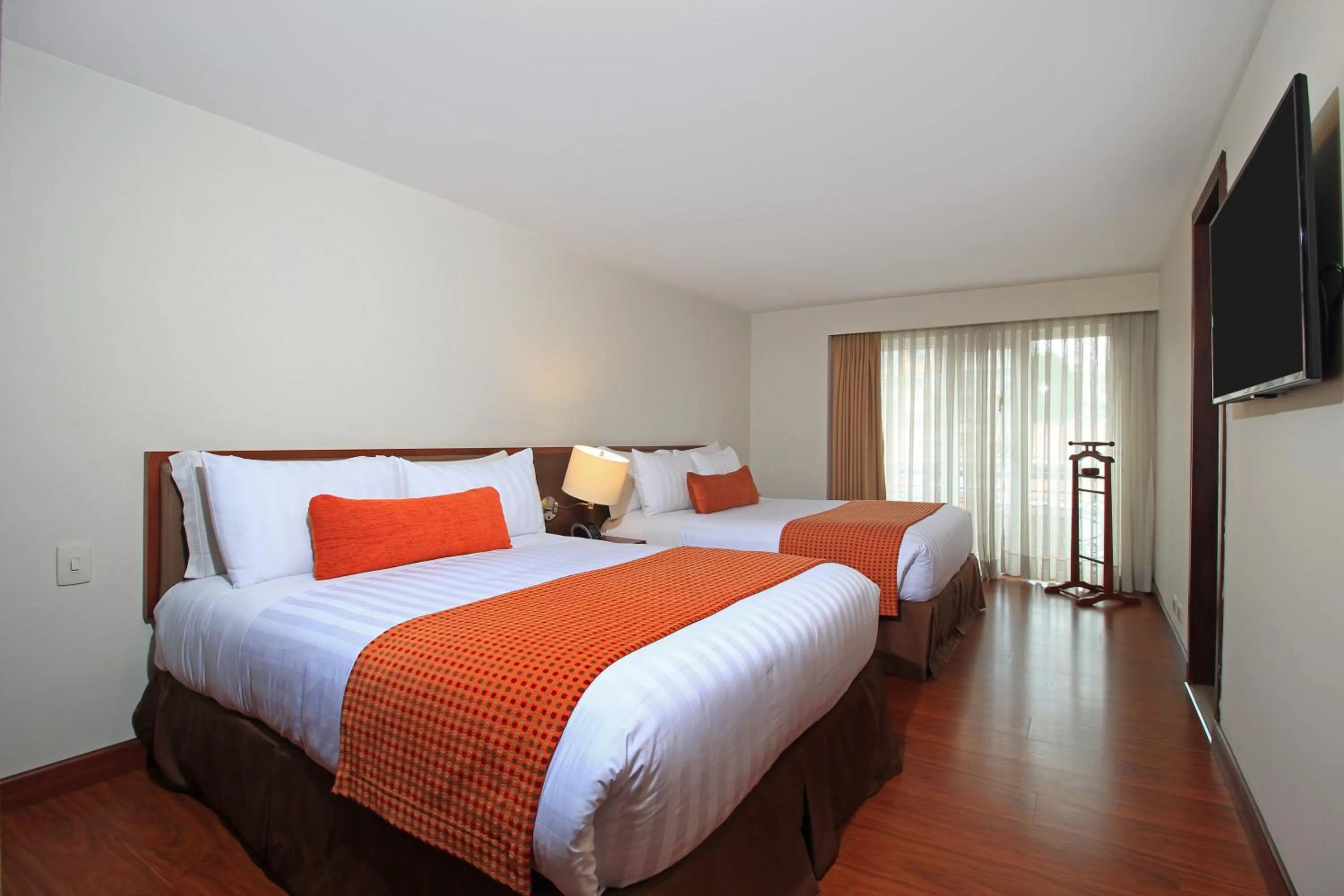 Bed in Hotel Windsor House Inn By GEH Suites