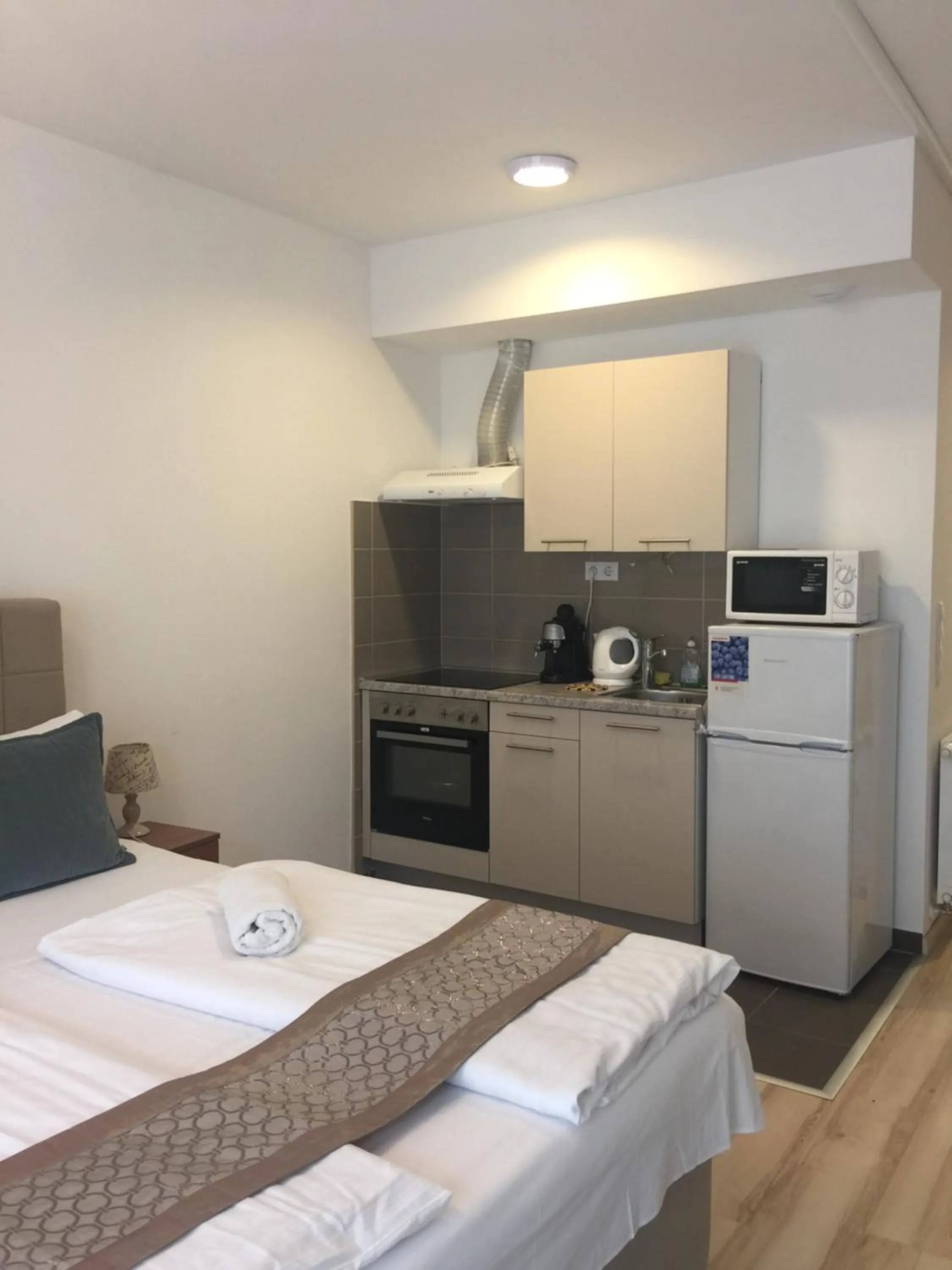 Kitchen or kitchenette, Bed in Corvin Rose Apartment Hotel