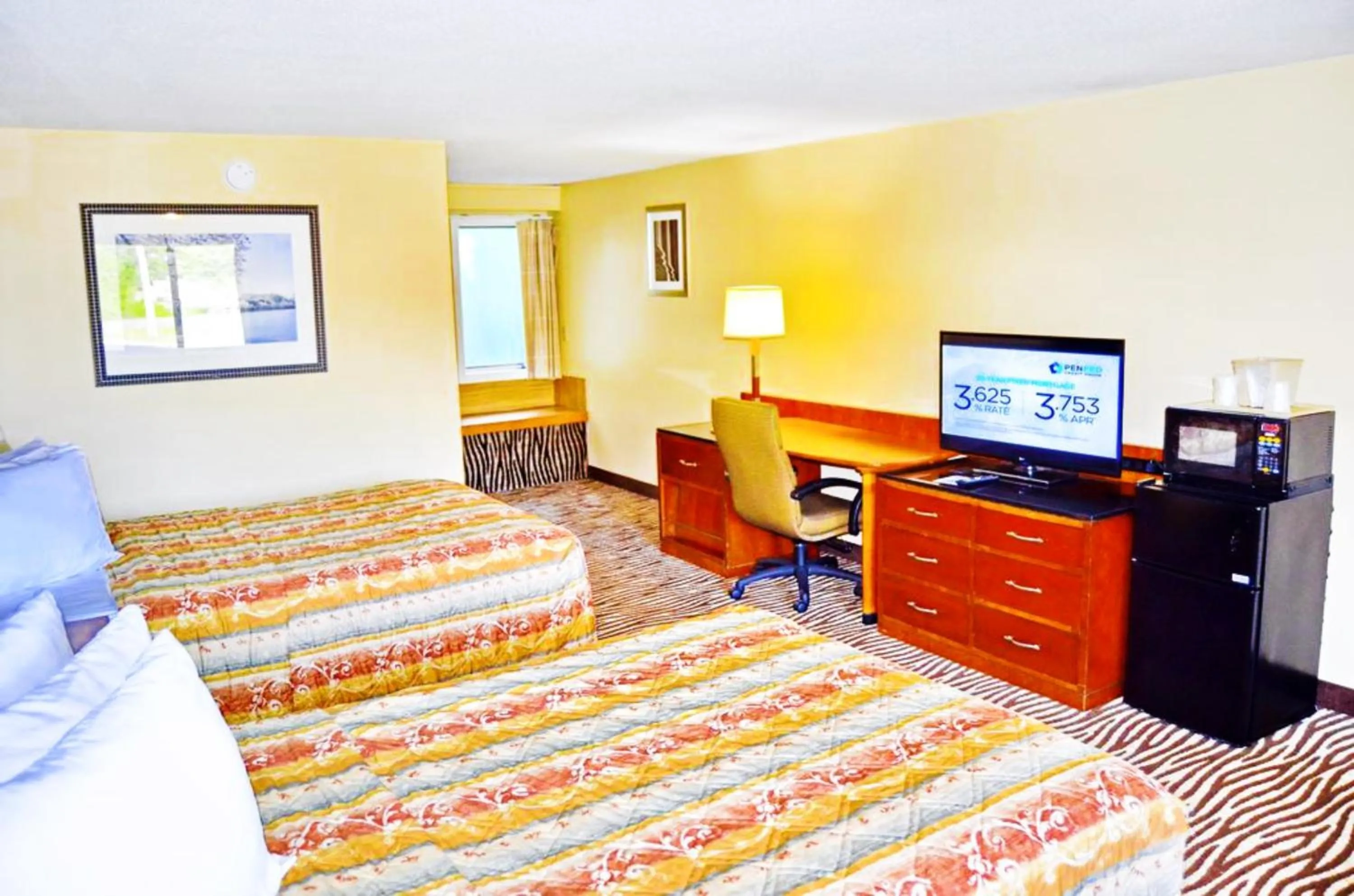 Communal lounge/ TV room, Bed in Flagship Inn & Suites