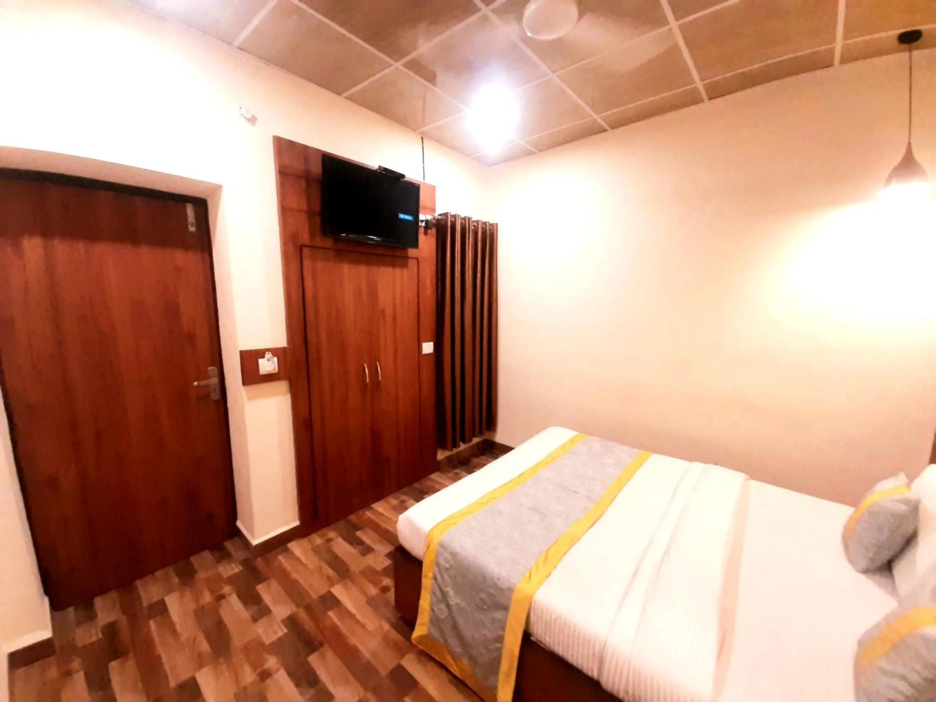 Communal lounge/ TV room, Bed in Luxmi Hotel