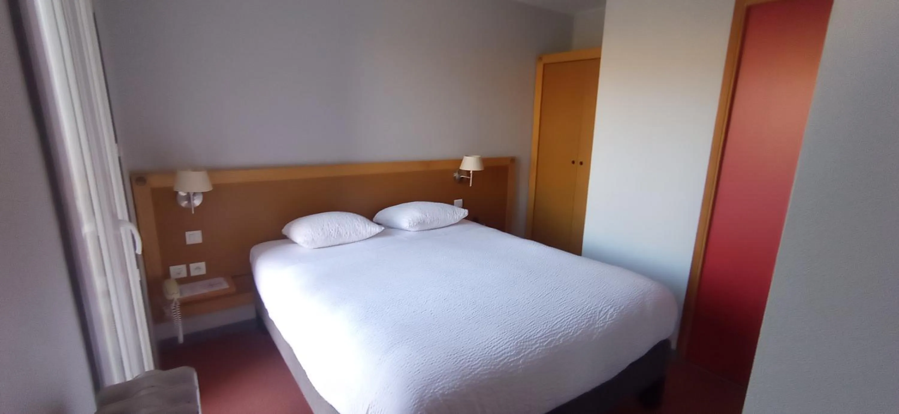 Bed in Logis Hotel Restaurant Le Cygne