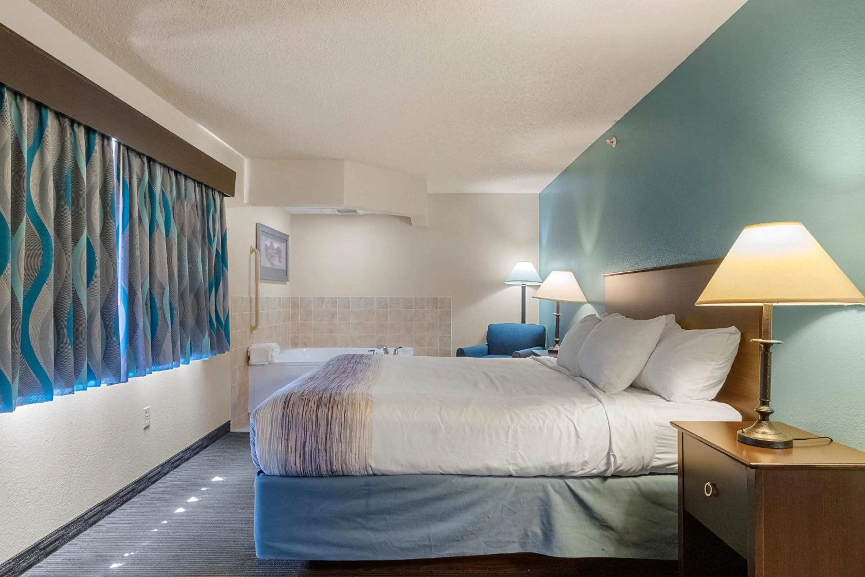 Seating area, Bed in AmericInn by Wyndham Green Bay East