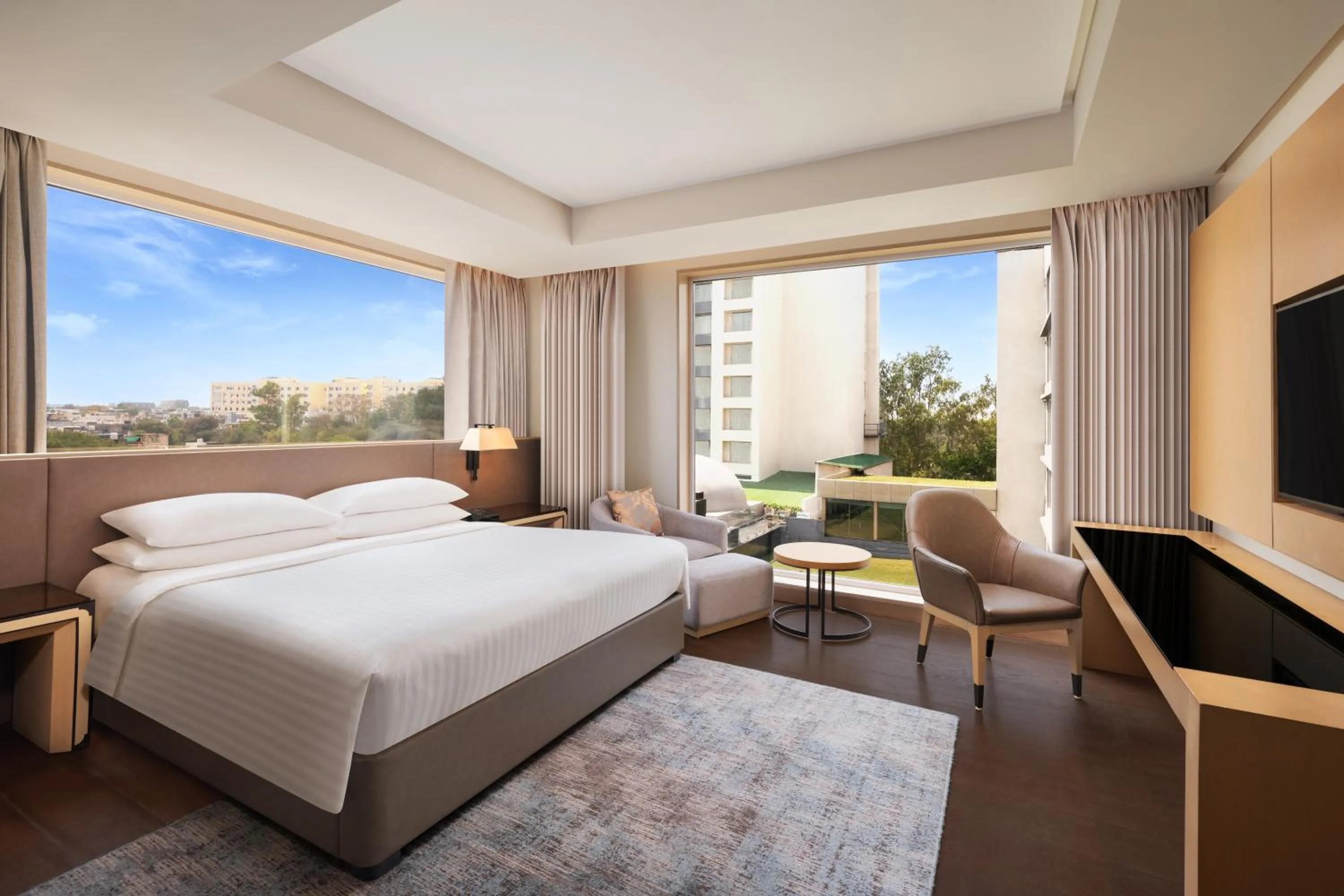 Communal lounge/ TV room, Bed in Indore Marriott Hotel