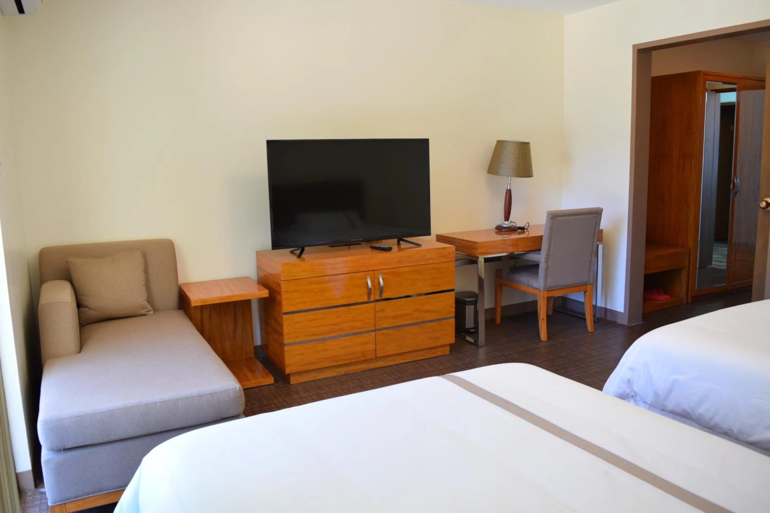 Communal lounge/ TV room, Bed in Saipan Beach Hotel