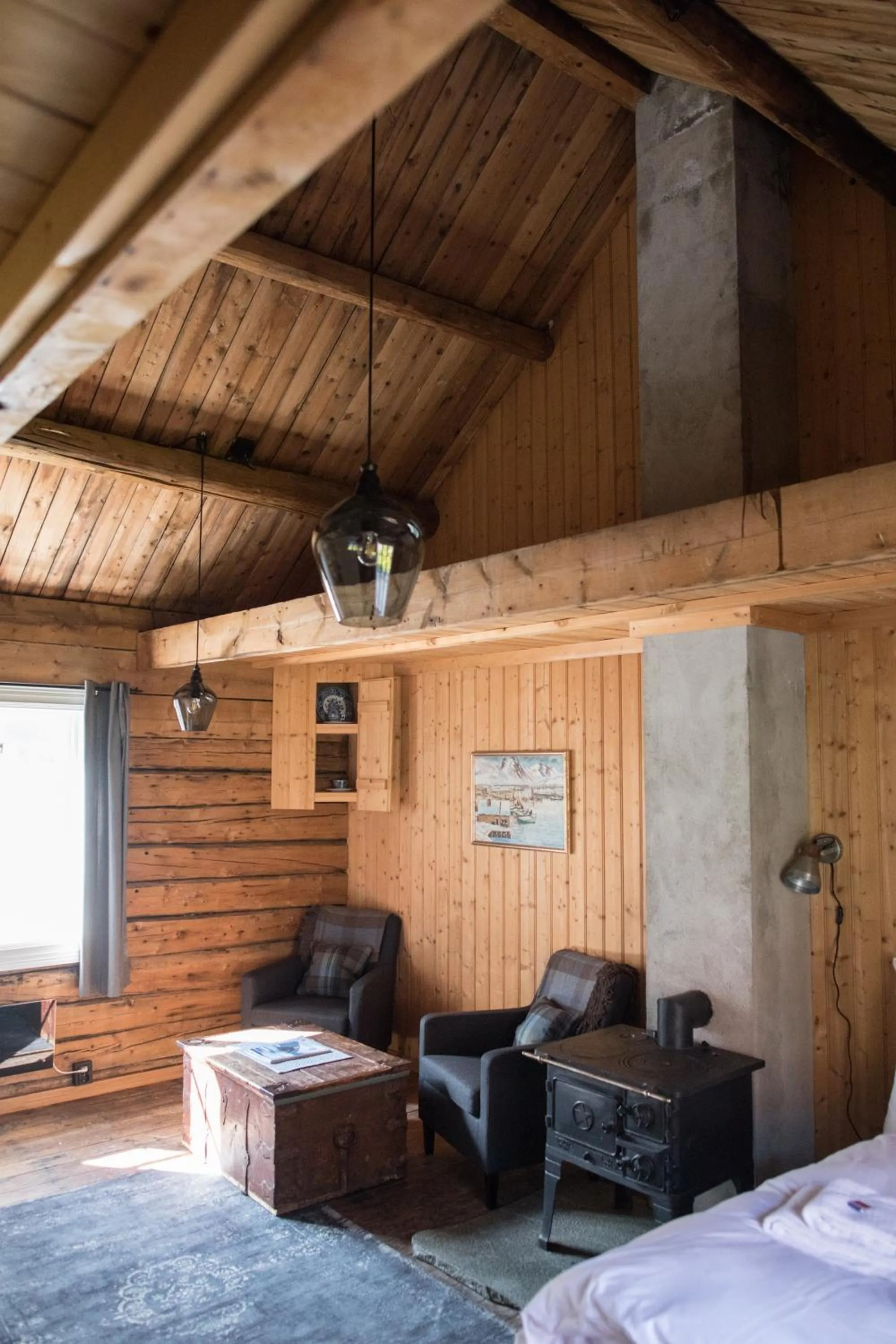 Seating area, Bed in Reine Rorbuer - by Classic Norway Hotels