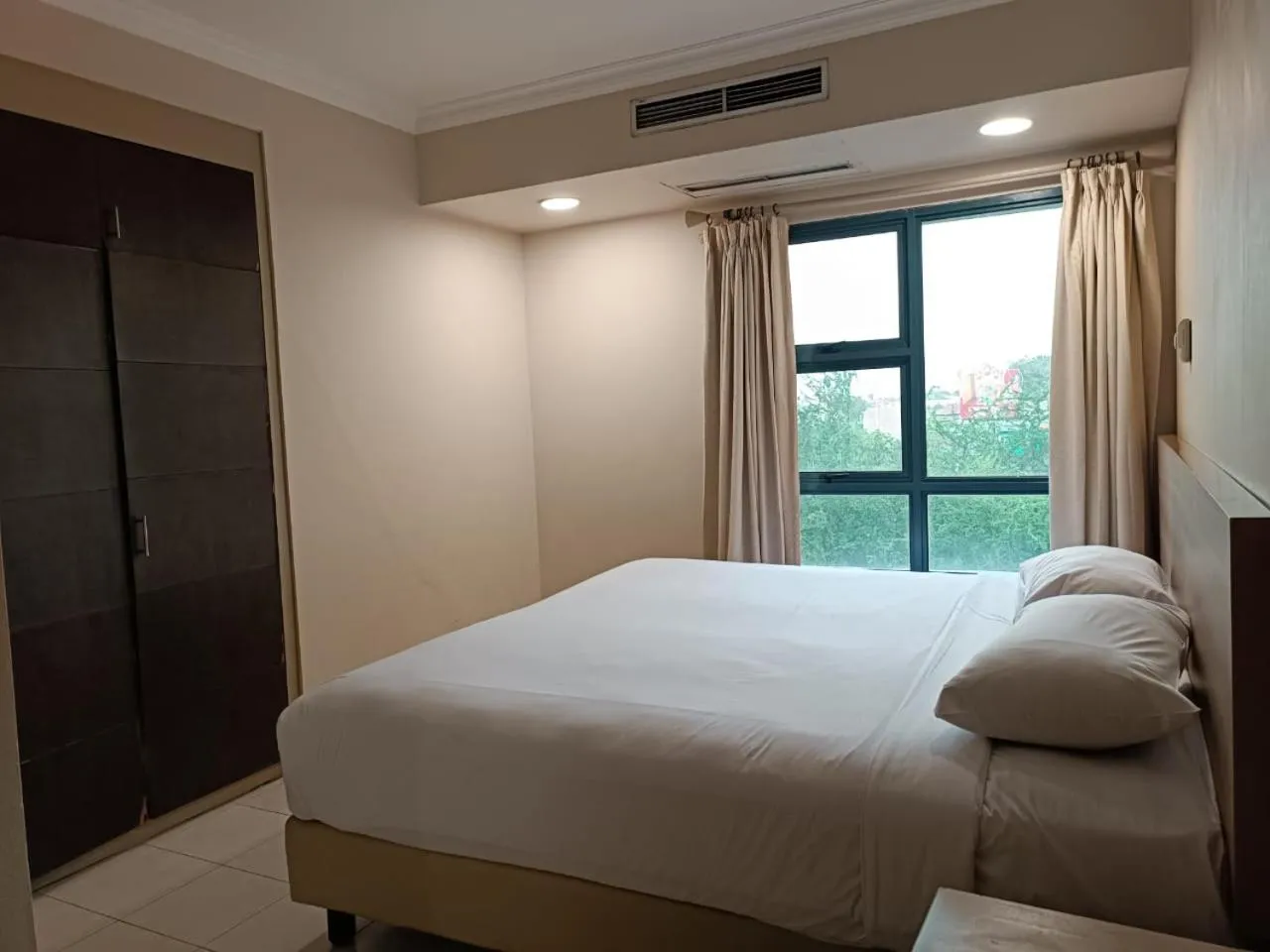 Bed in Grand Tropic Suites Hotel