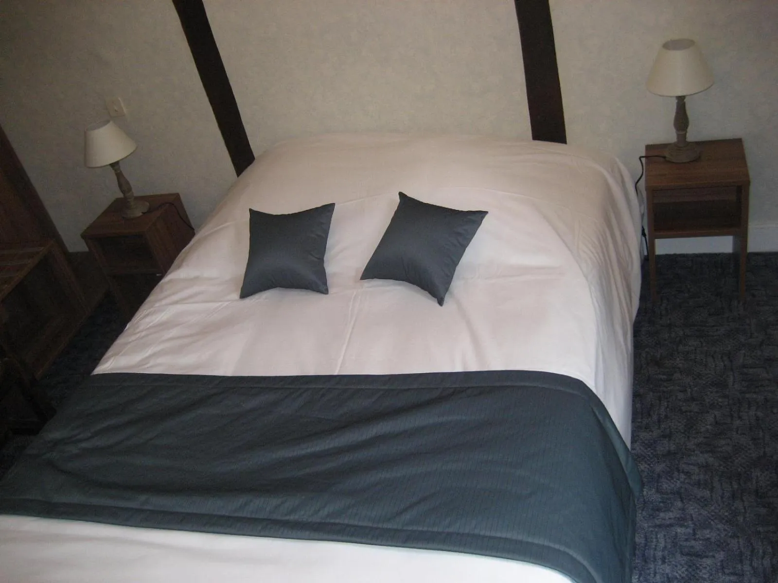 Bed in Logis Hotel Restaurant Le Cheval Blanc