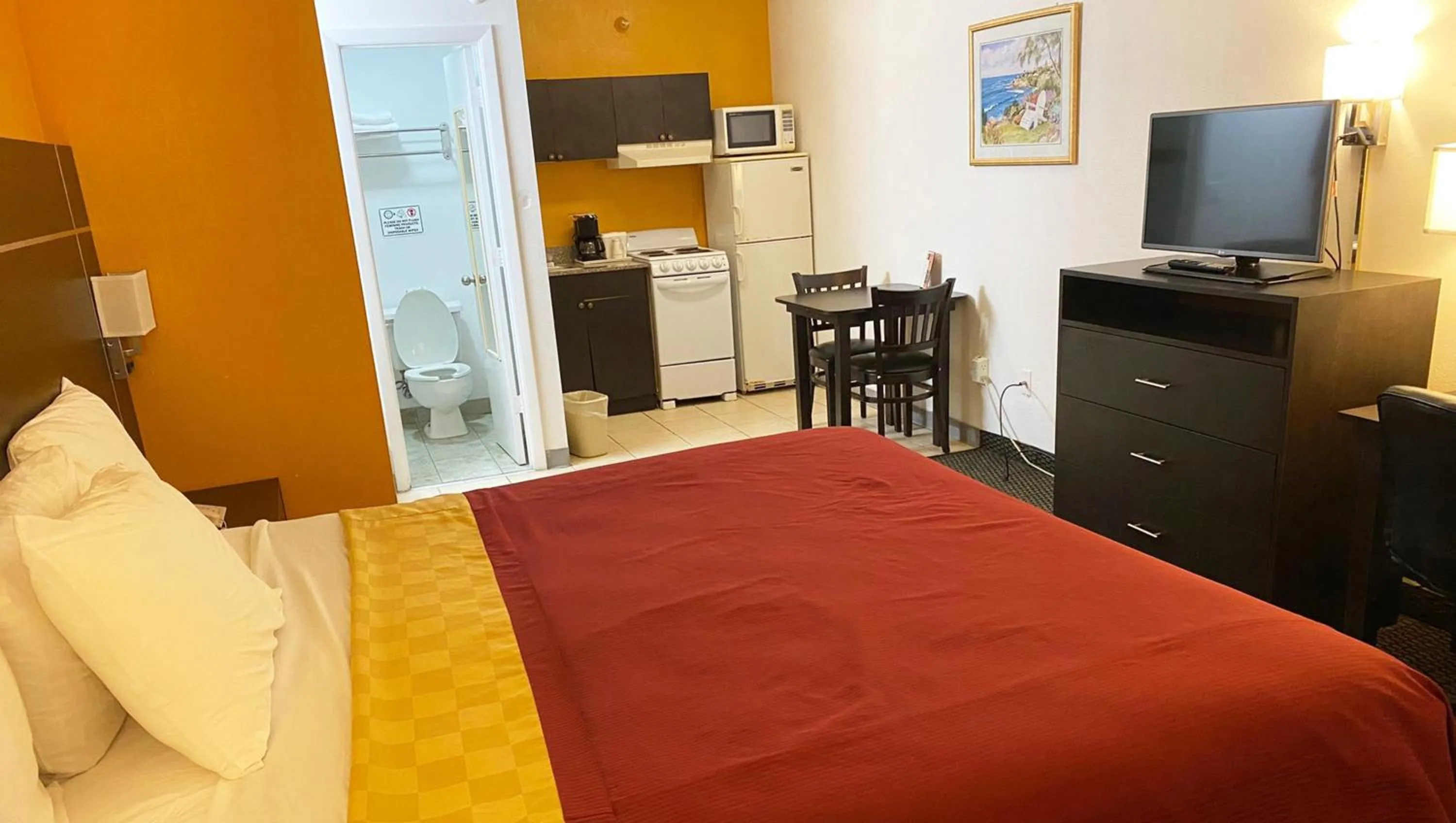 Kitchen or kitchenette, Bed in Magnuson Hotel Bradenton