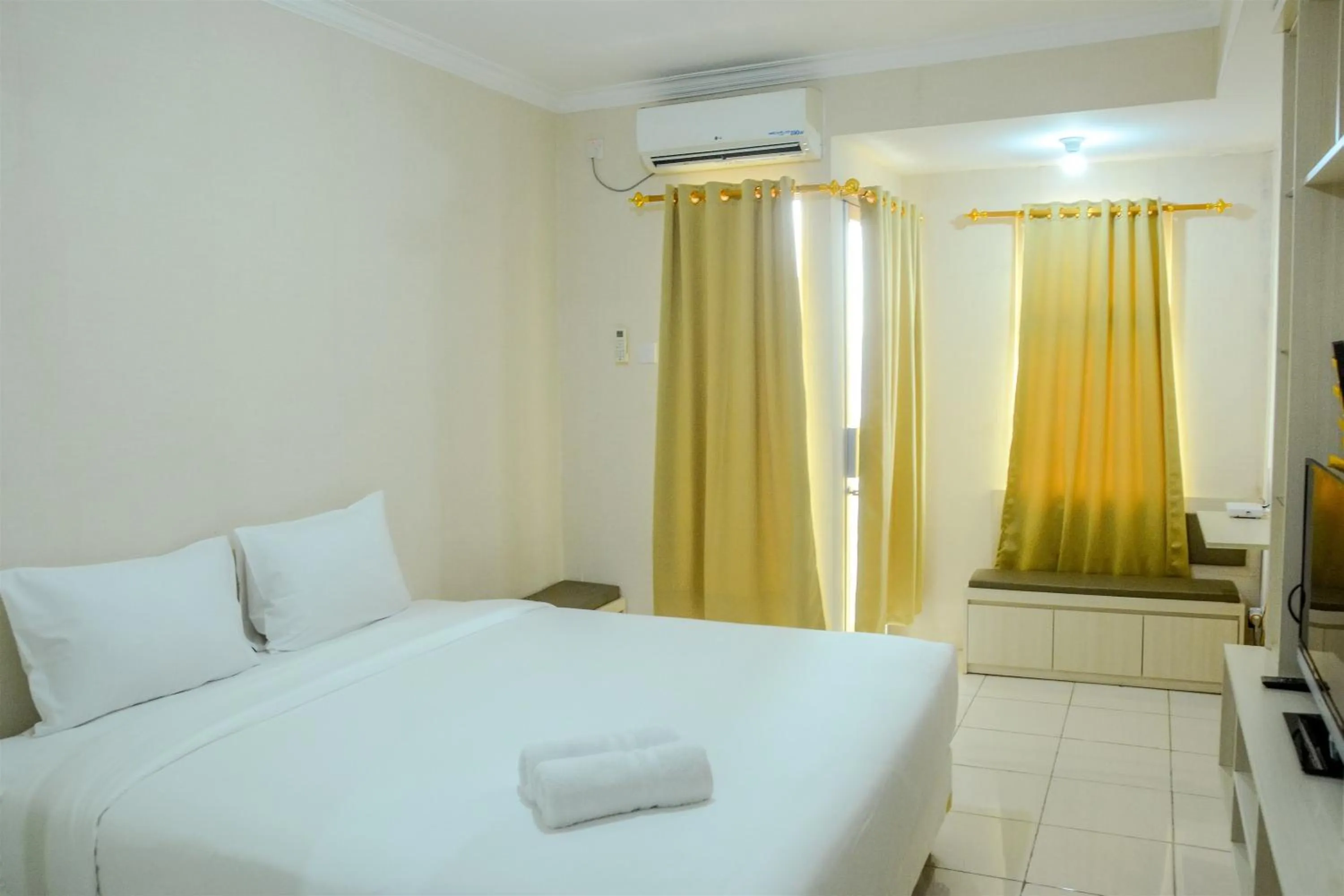 Bed in Minimalist Studio Room at Grand Serpong Apartment By Travelio