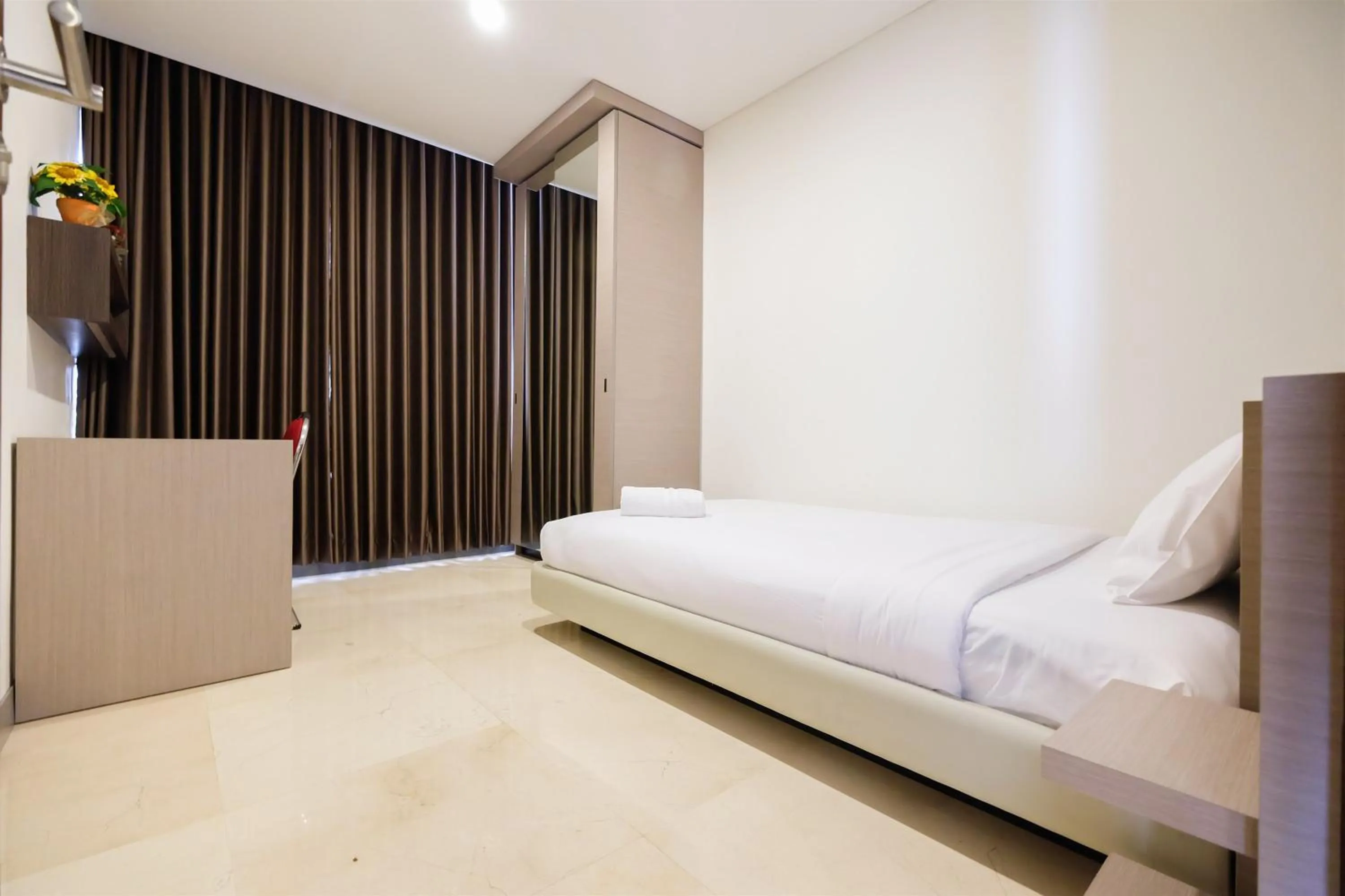 Bed in Modern Elegant Design 2BR L'Avenue Apartment By Travelio