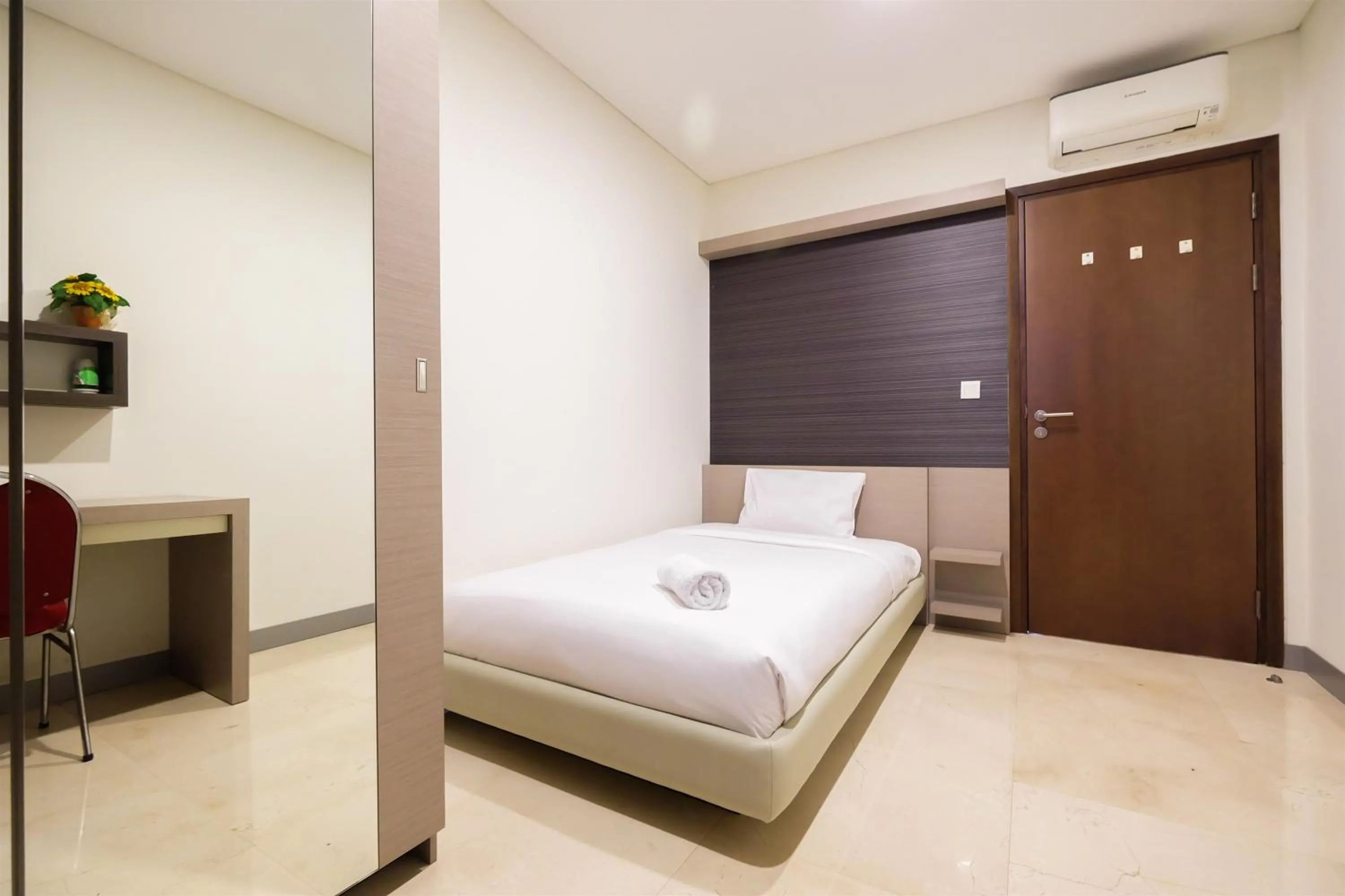 Bed in Modern Elegant Design 2BR L'Avenue Apartment By Travelio