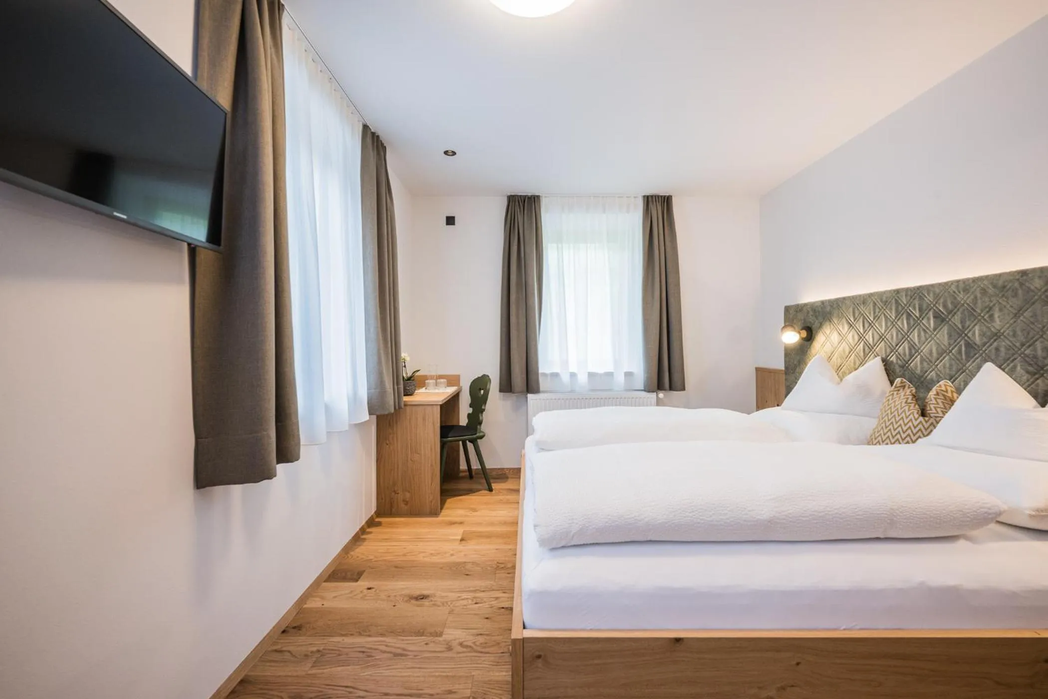 Communal lounge/ TV room, Bed in Gasthof Albergo Dolomiten